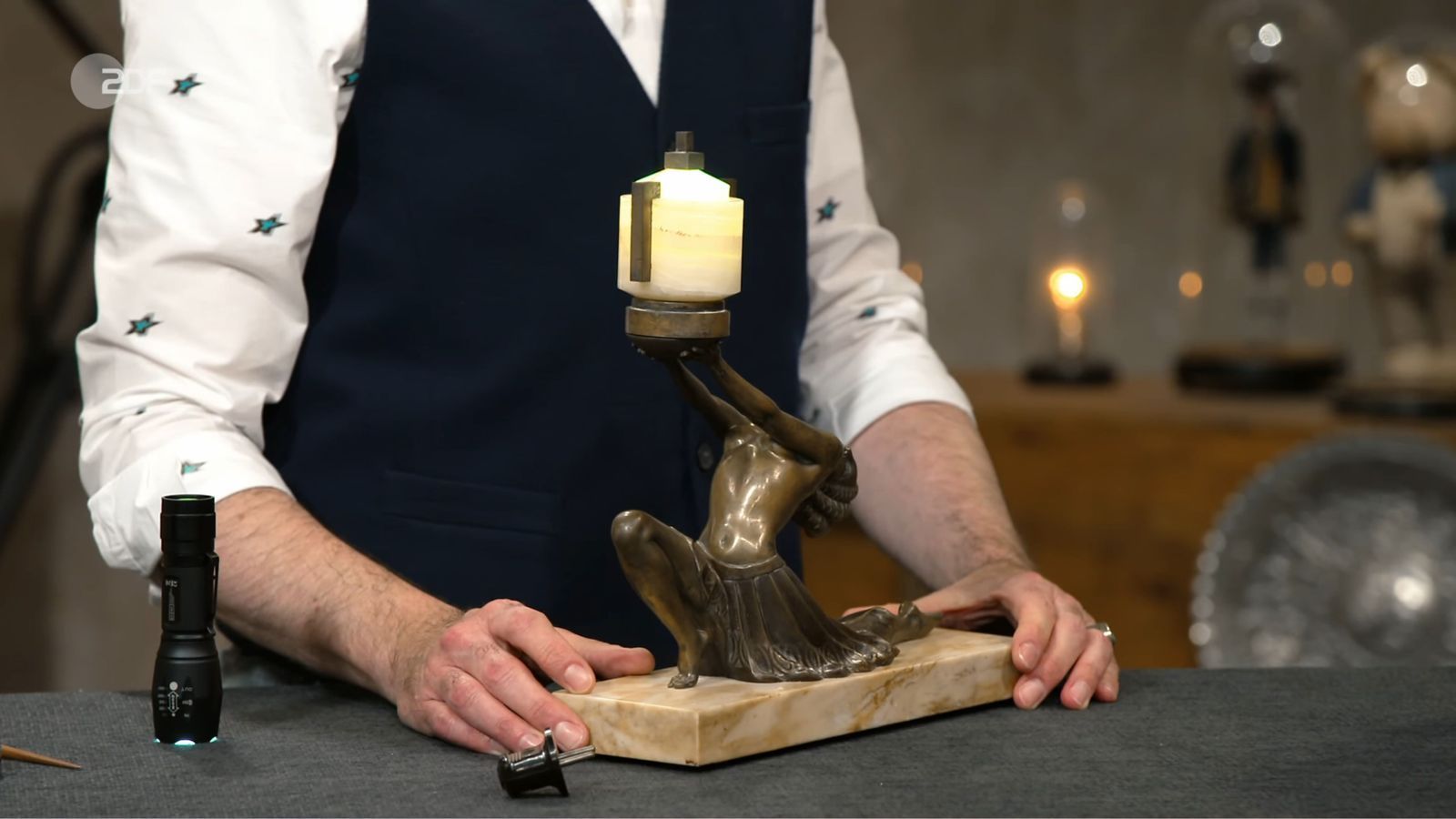 „Das auf dem richtigen Schreibtisch - ein Träumchen!“, sinnierte Lichter über die Leuchte mit Bronzefigur. Stolze 2.000 Euro schwebten Anna und Lukas vor, doch Colmar Schulte-Goltz bremste auf 800. Die beiden lehnten ab und nahmen die Lichtgestalt wieder mit nach Hause. (Bild: ZDF)