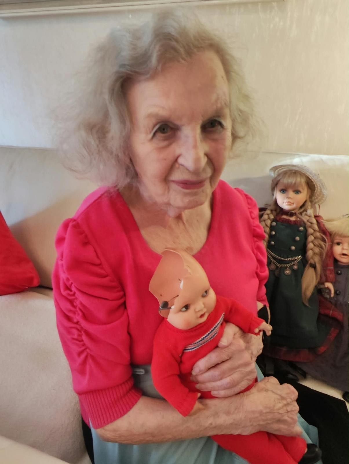 Paula Hilsemer hält ihre alte Puppe im Arm, deren Kopf kaputt ist.