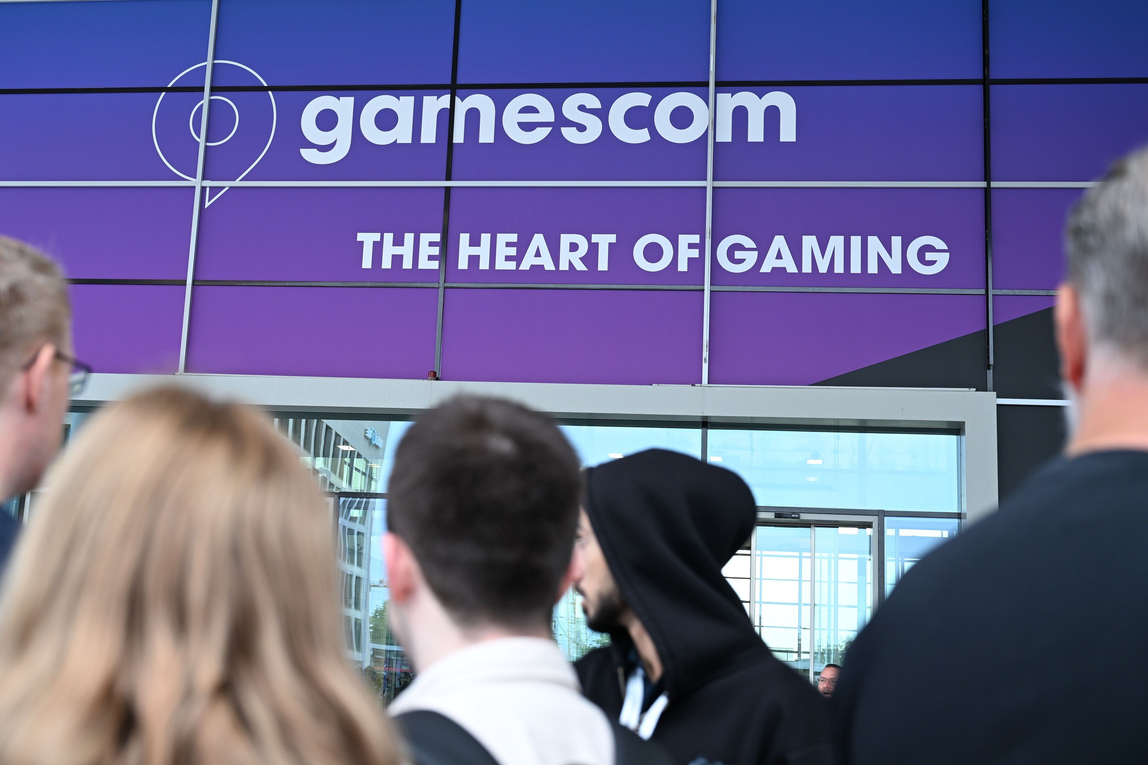 Besucherinnen und Besucher stehen am Eingang der Koelnmesse und warten darauf, dass die Gamescom ihre Türen öffnet (Archivbild).
