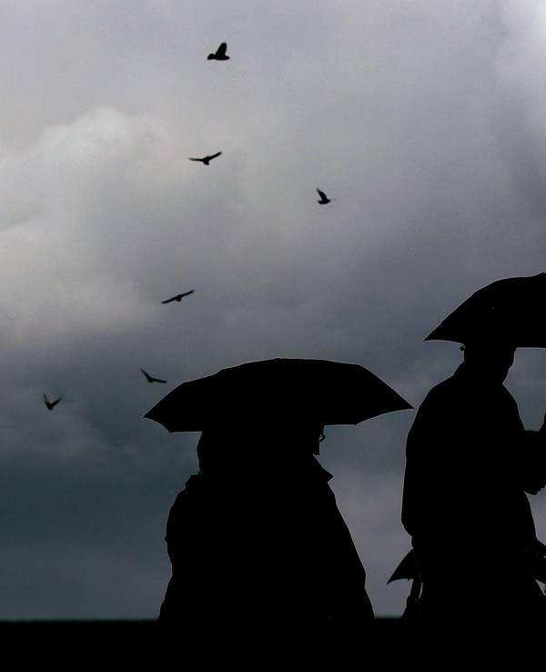 Menschen laufen mit Regenschirmen durch die Kölner Innenstadt (Archivbild).