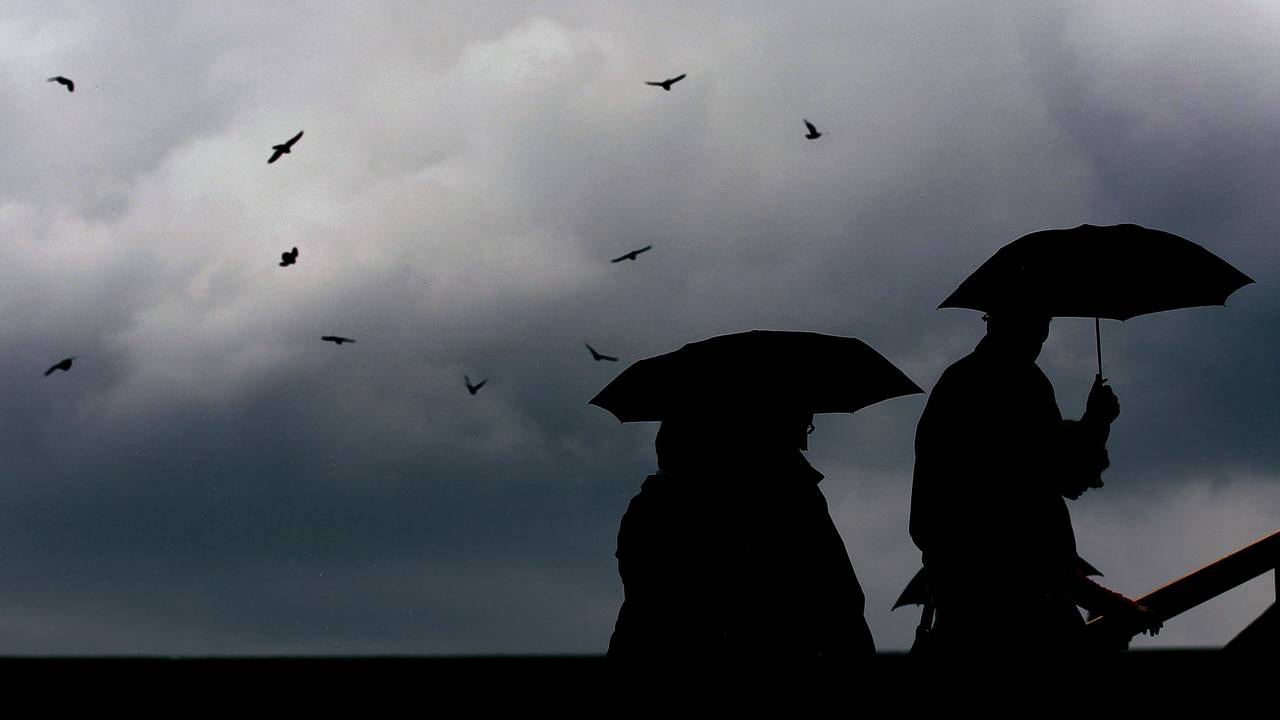 Menschen laufen mit Regenschirmen durch die Kölner Innenstadt (Archivbild).