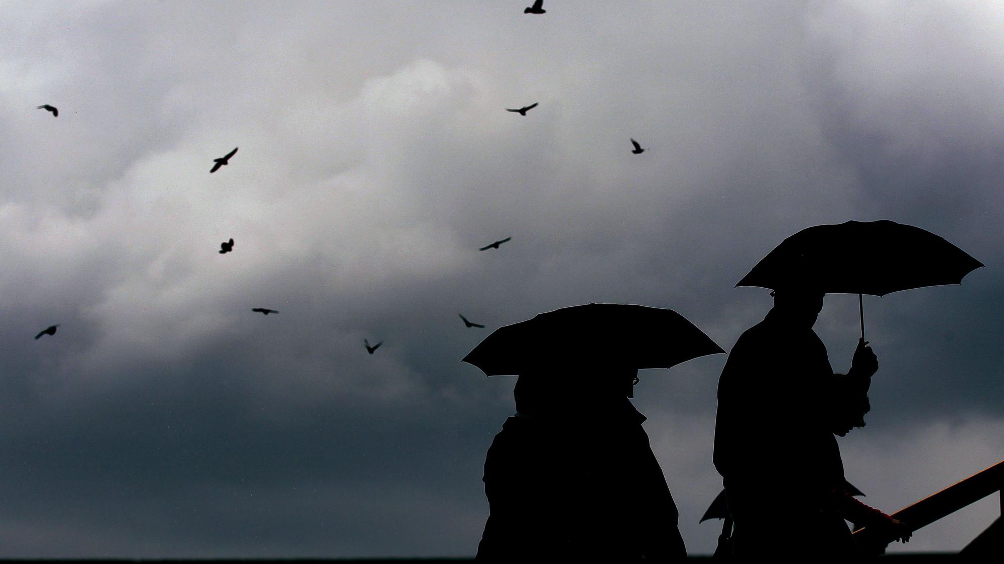 Menschen laufen mit Regenschirmen durch die Kölner Innenstadt (Archivbild).