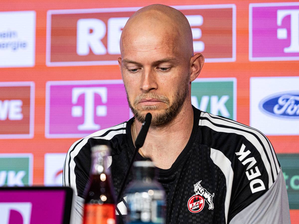 René Wagner sitzt bei einer Pressekonferenz und zieht die Mundwinkel nach unten.