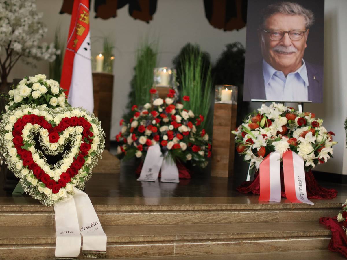 Ein Herz aus Blumen und zahlreiche Kränze umgeben den Sarg von Fritz Schramma.
