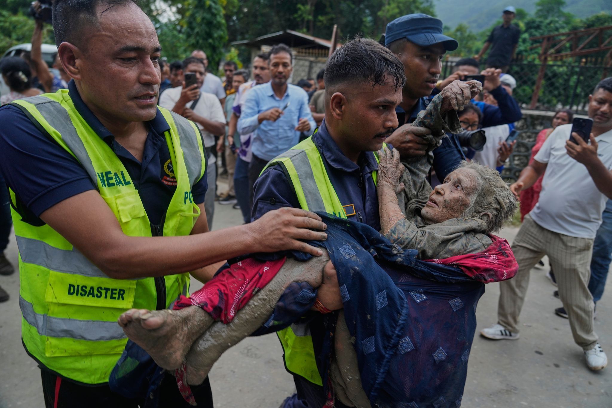 Sturzflut an Grenze zwischen China und Nepal: Rettungskräfte tragen eine Frau aus dem Schlamm.