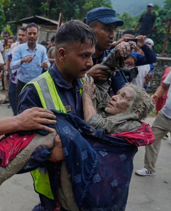 Sturzflut an Grenze zwischen China und Nepal: Rettungskräfte tragen eine Frau aus dem Schlamm.