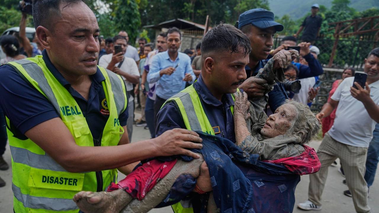 Sturzflut an Grenze zwischen China und Nepal: Rettungskräfte tragen eine Frau aus dem Schlamm.