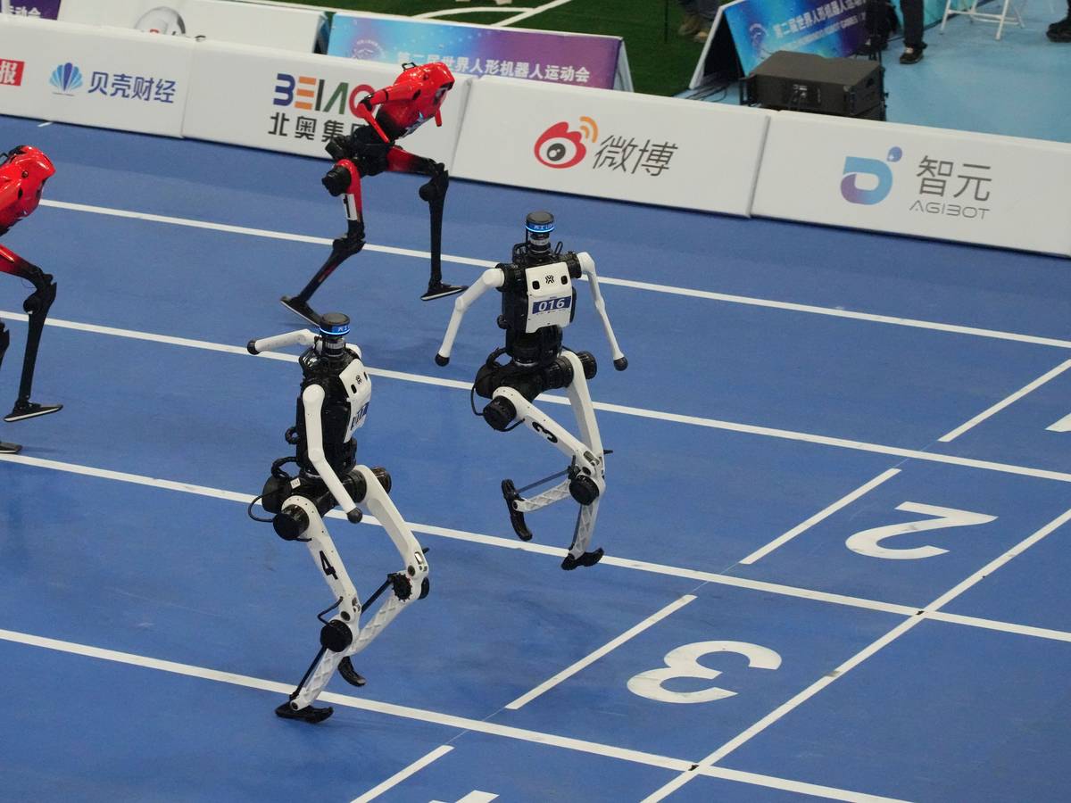 Humanoide Roboter treten bei den World Humanoid Robot Games in der chinesischen Hauptstadt im 100-Meter-Lauf gegeneinander an. Ländern teil. Foto: Achmad Ibrahim/AP/dpa +++ dpa-Bildfunk +++