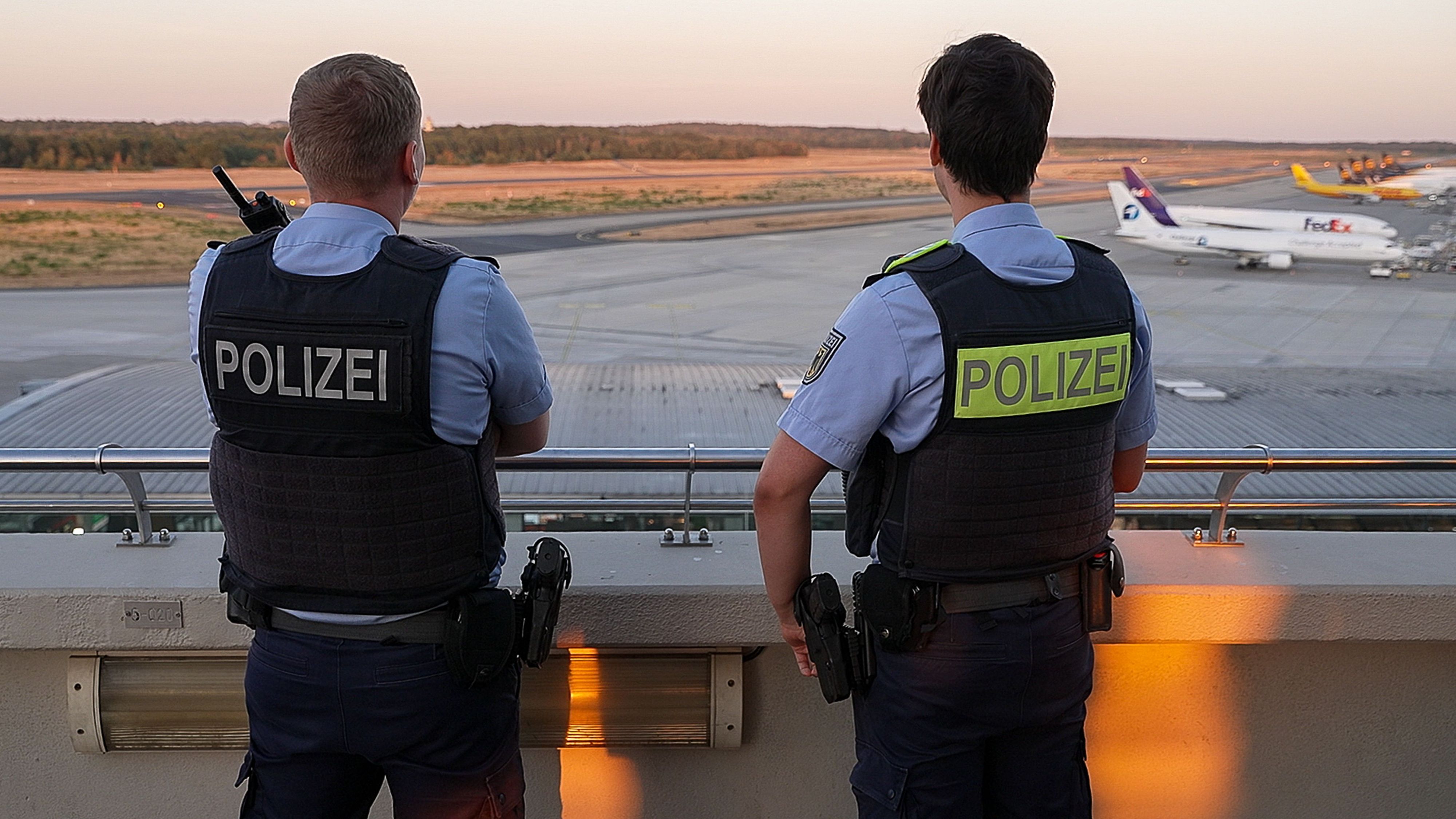 Einsatzkräfte der Polizei blicken auf das Gelände des Flughafens Köln/Bonn. (Symbolfoto)