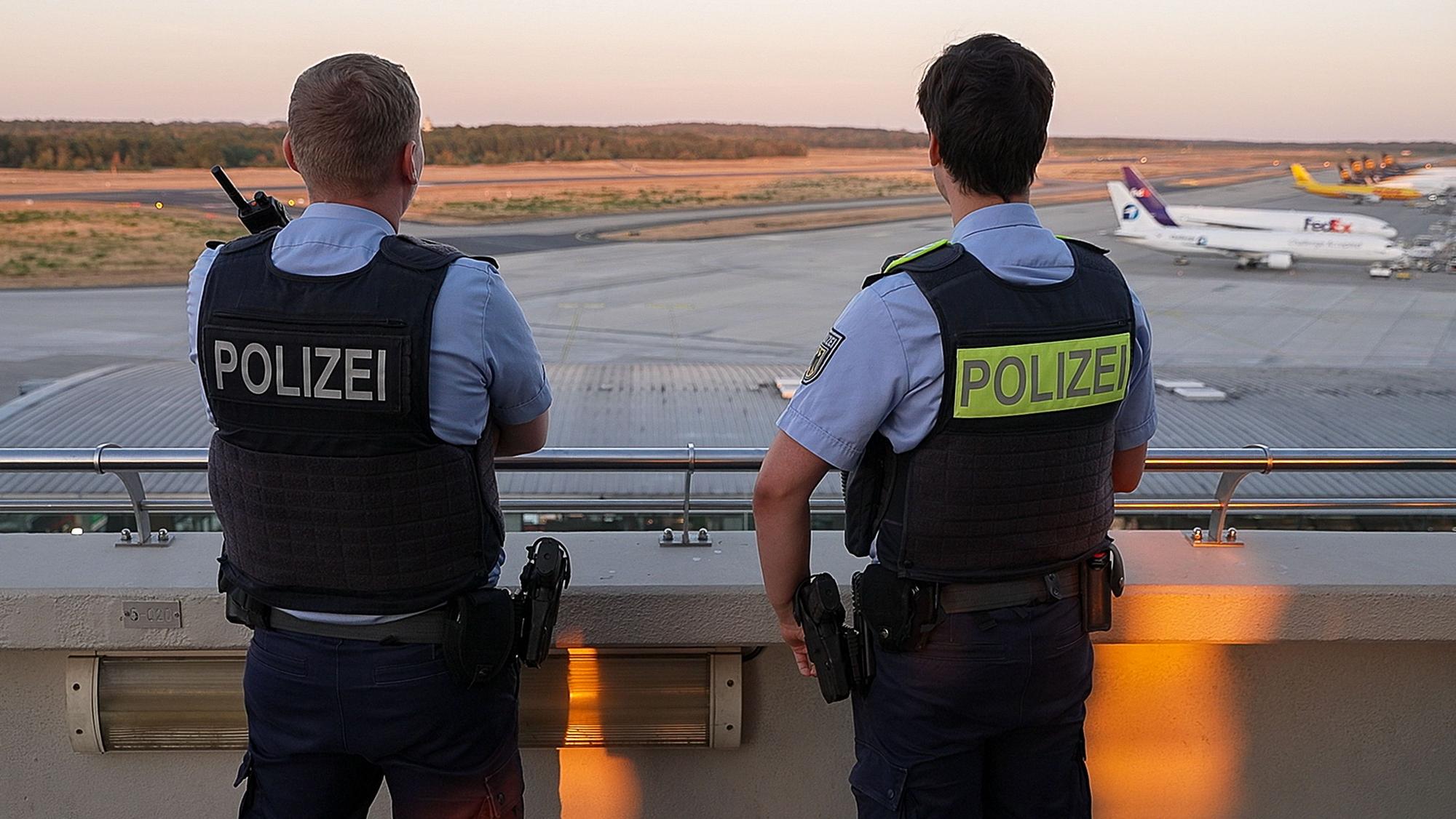 Einsatzkräfte der Polizei blicken auf das Gelände des Flughafens Köln/Bonn. (Symbolfoto)