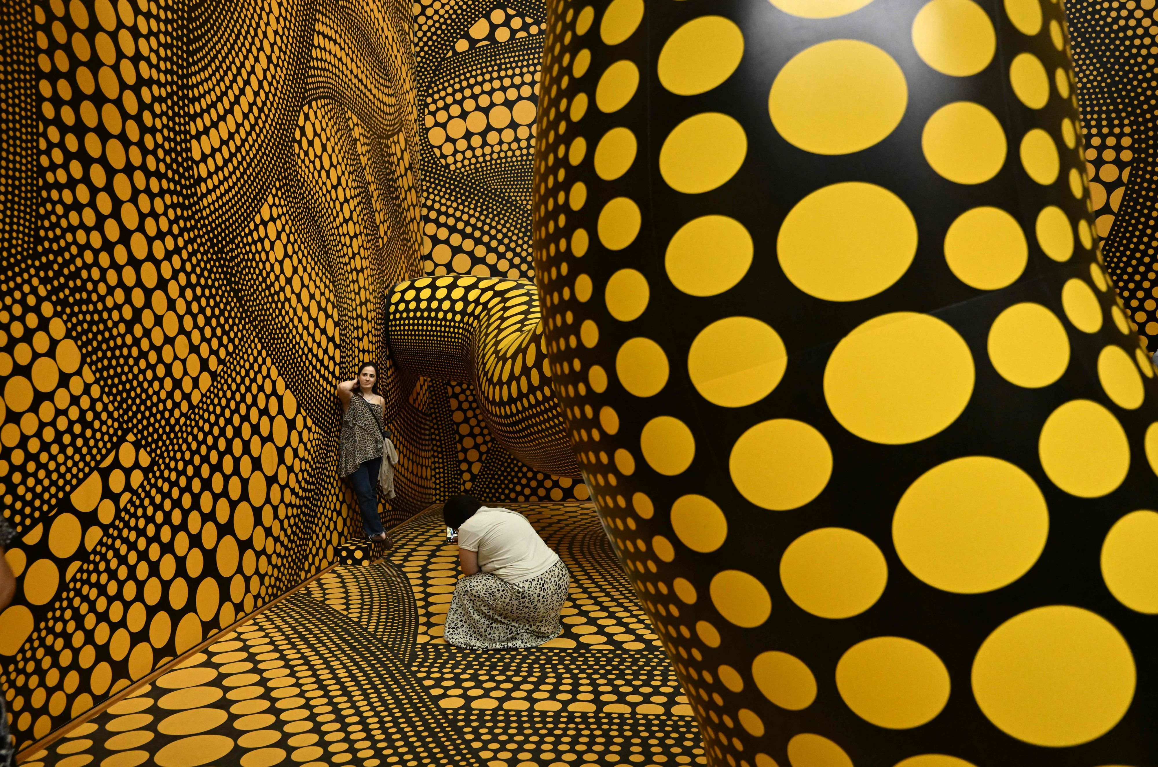Besucher machen Fotos der Installation „Infinity Mirrored Room – The Hope of the Polka Dots Buried in Infinity Will Eternally Cover the Universe“ im Museum Ludwig in Köln.