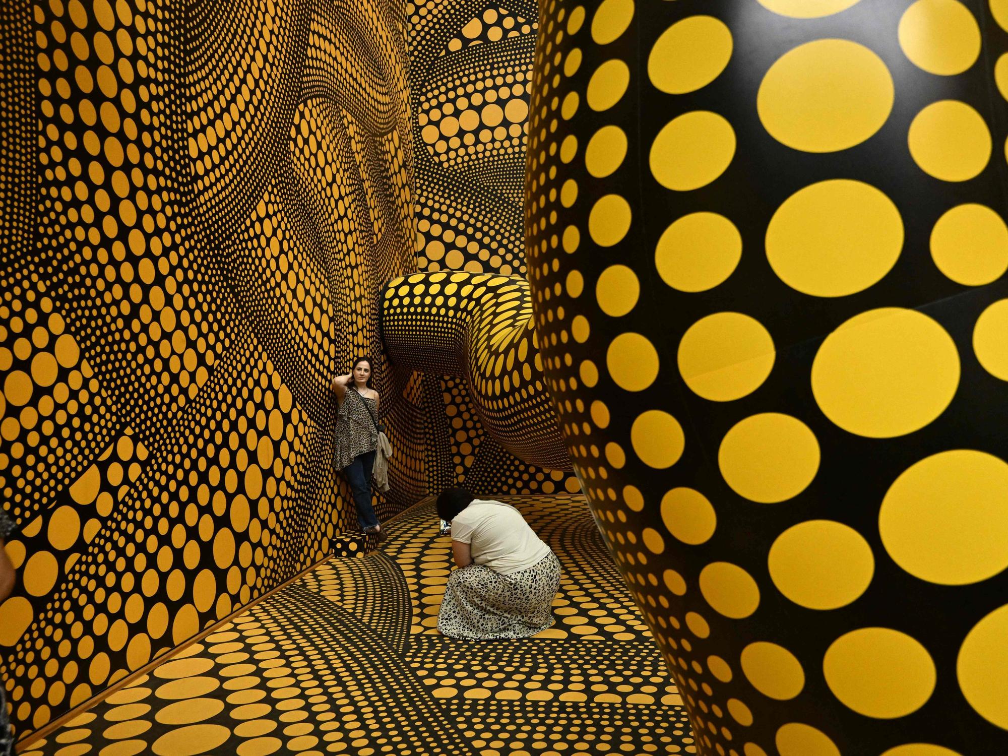 Besucher machen Fotos der Installation „Infinity Mirrored Room – The Hope of the Polka Dots Buried in Infinity Will Eternally Cover the Universe“ im Museum Ludwig in Köln.