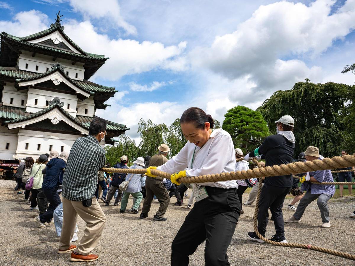 Nach den Restaurierungsarbeiten in Hirosaki in der Präfektur Aomori ziehen Freiwillige am 26. August 2026 einen Teil der Burg Hirosaki mit Seilen an ihren ursprünglichen Standort zurück.