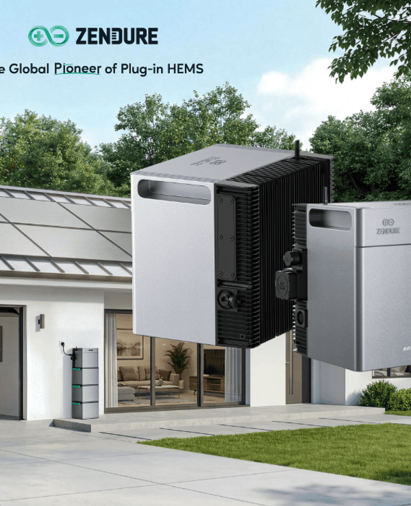 Ein Haus mit Solarmodulen auf dem Dach im Hintergrund. Im Vordergrund sind zwei Speicher zu sehen.
