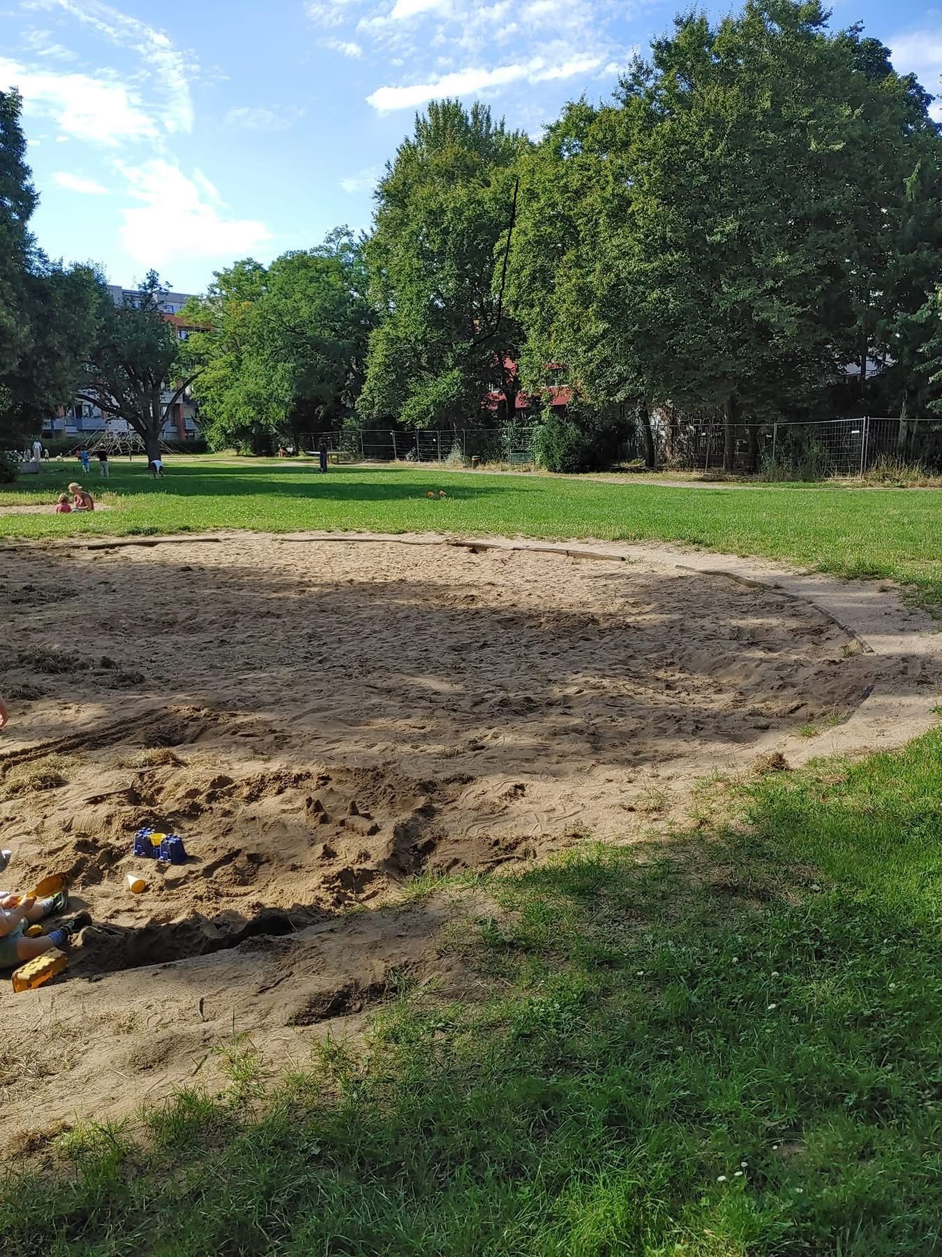 Ein Spielplatz mit einer großen Sandkiste.