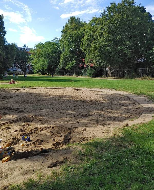 Ein Spielplatz mit einer großen Sandkiste.