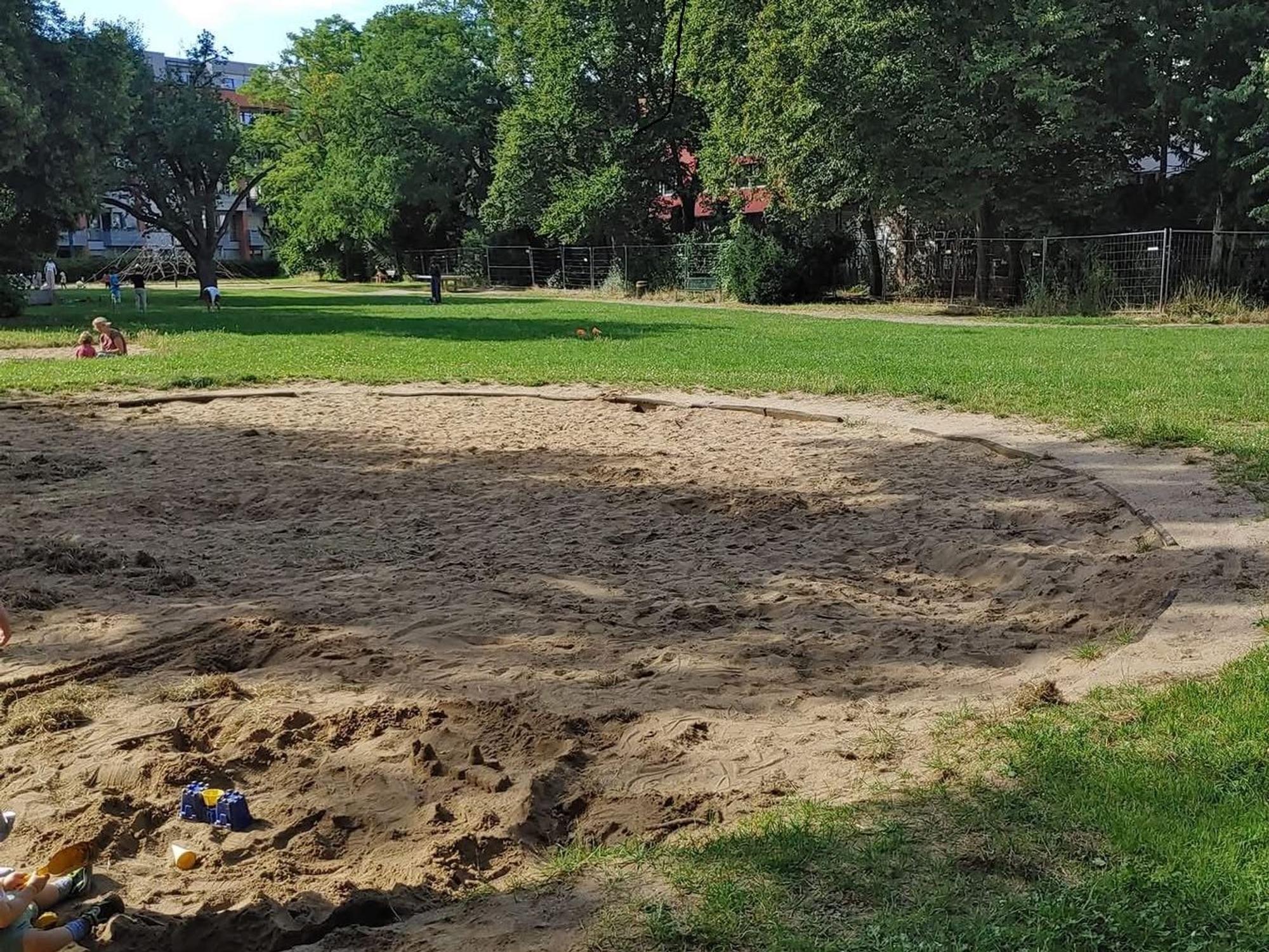 Ein Spielplatz mit einer großen Sandkiste.