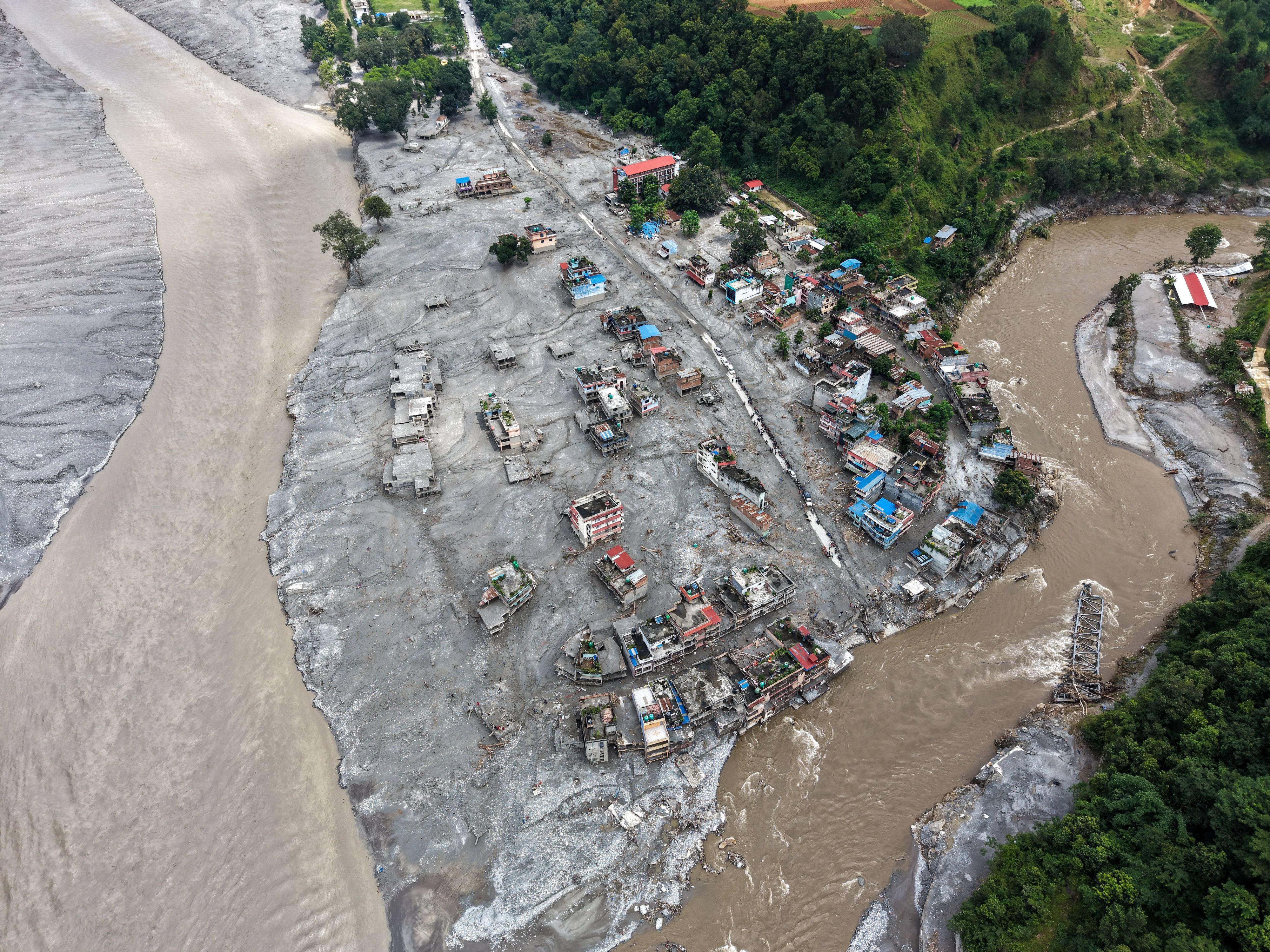 Ein Luftbild zeigt Häuser in einer Stadt am Trishuli-Fluss, die durch die Sturzfluten zerstört wurden