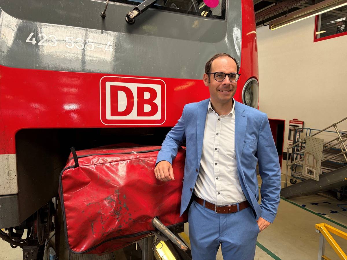 Markus Kaupper stützt einen Arm auf eine DB-Bahn.
