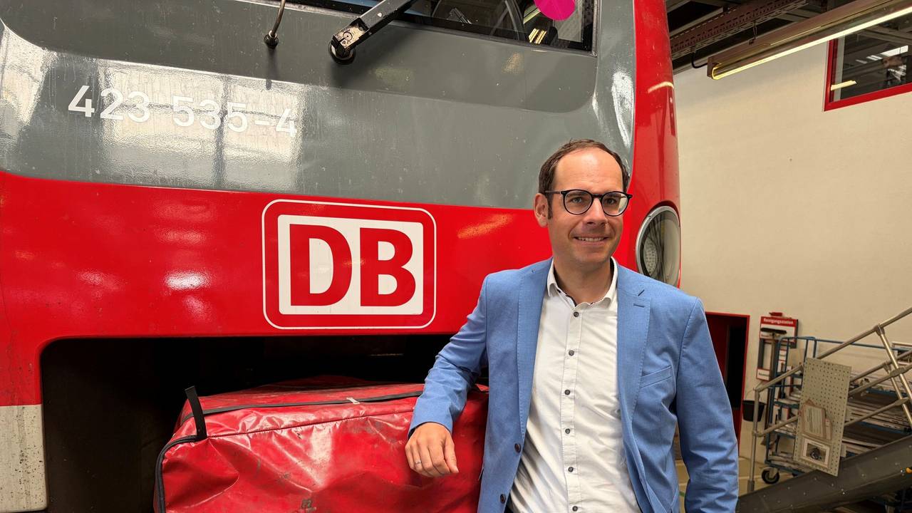Markus Kaupper stützt einen Arm auf eine DB-Bahn.