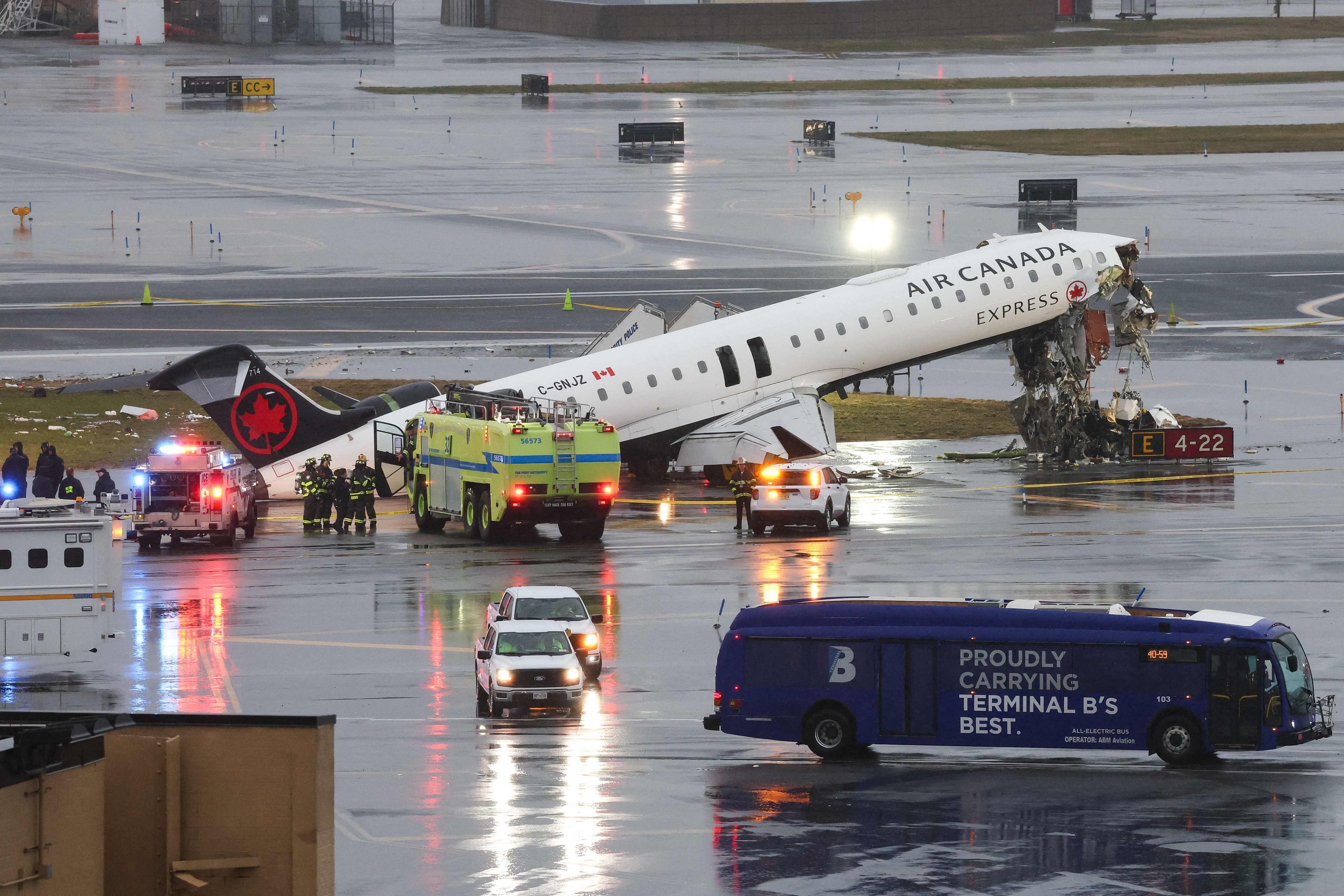Ein Flugzeug von Air Canada steht beschädigt auf einer Landebahn, Feuerwehrleute sind im Einsatz.