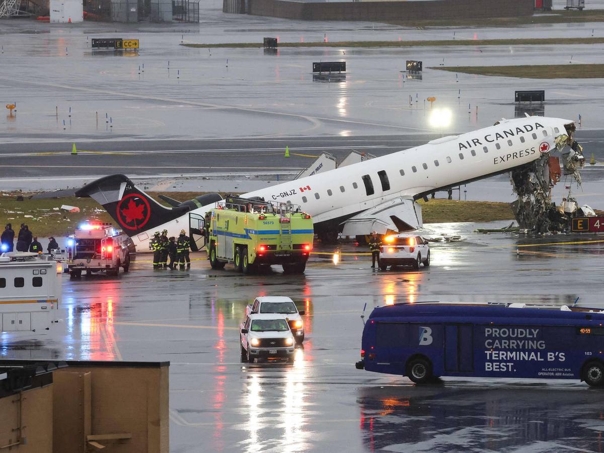 Ein Flugzeug von Air Canada steht beschädigt auf einer Landebahn, Feuerwehrleute sind im Einsatz.