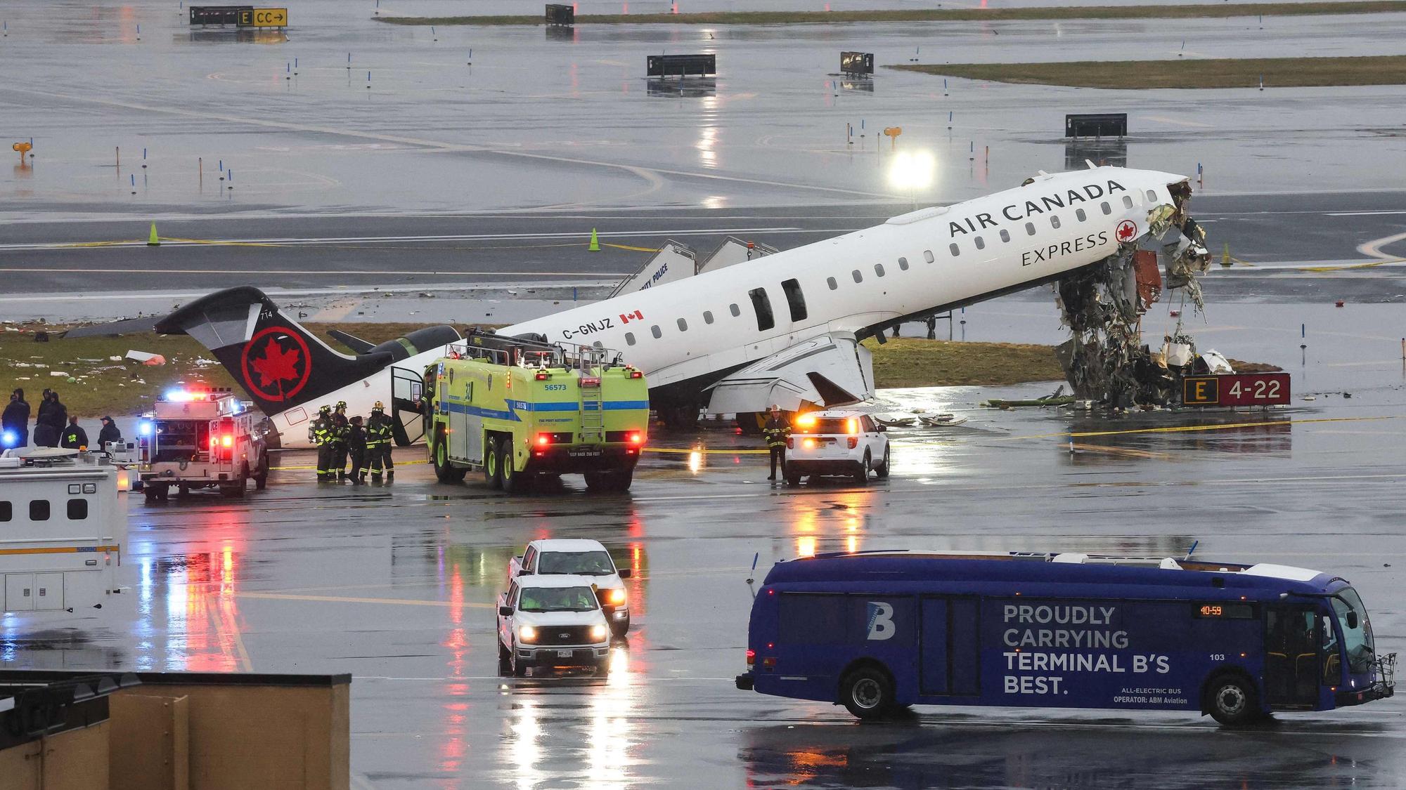 Ein Flugzeug von Air Canada steht beschädigt auf einer Landebahn, Feuerwehrleute sind im Einsatz.