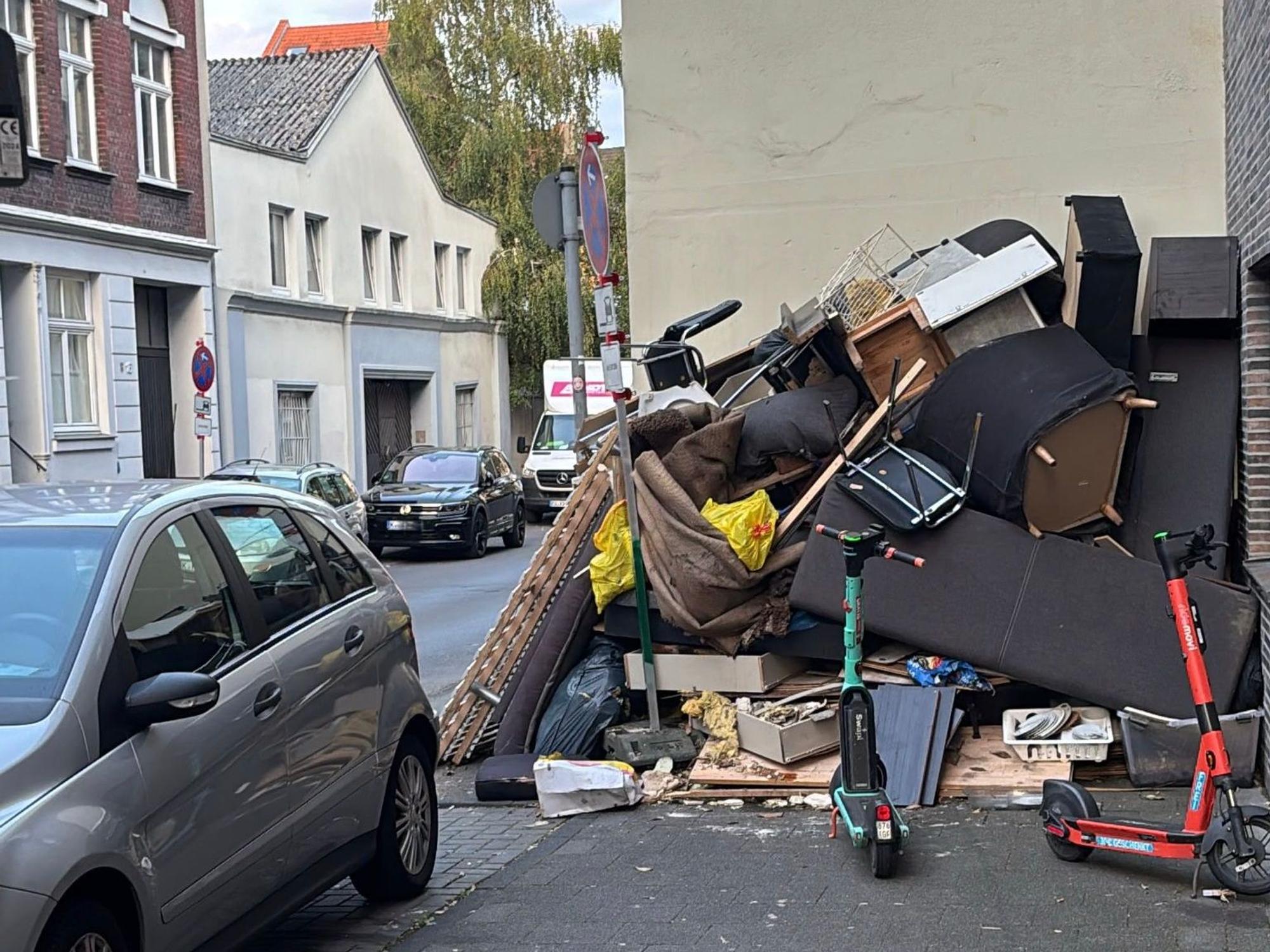 Ein Berg aus Sperrmüll türmt sich an einer Hauswand.