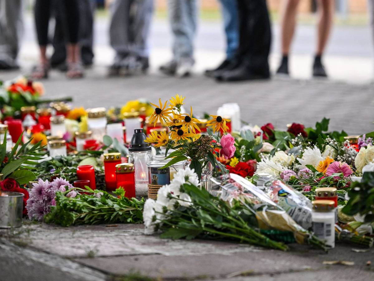 Blumen und Kerzen liegen vor einer Schule im Landkreis Oder-Spree. Dort wurden eine 18-jährige Schülerin und ein 30-jähriger Kita-Erzieher getötet.