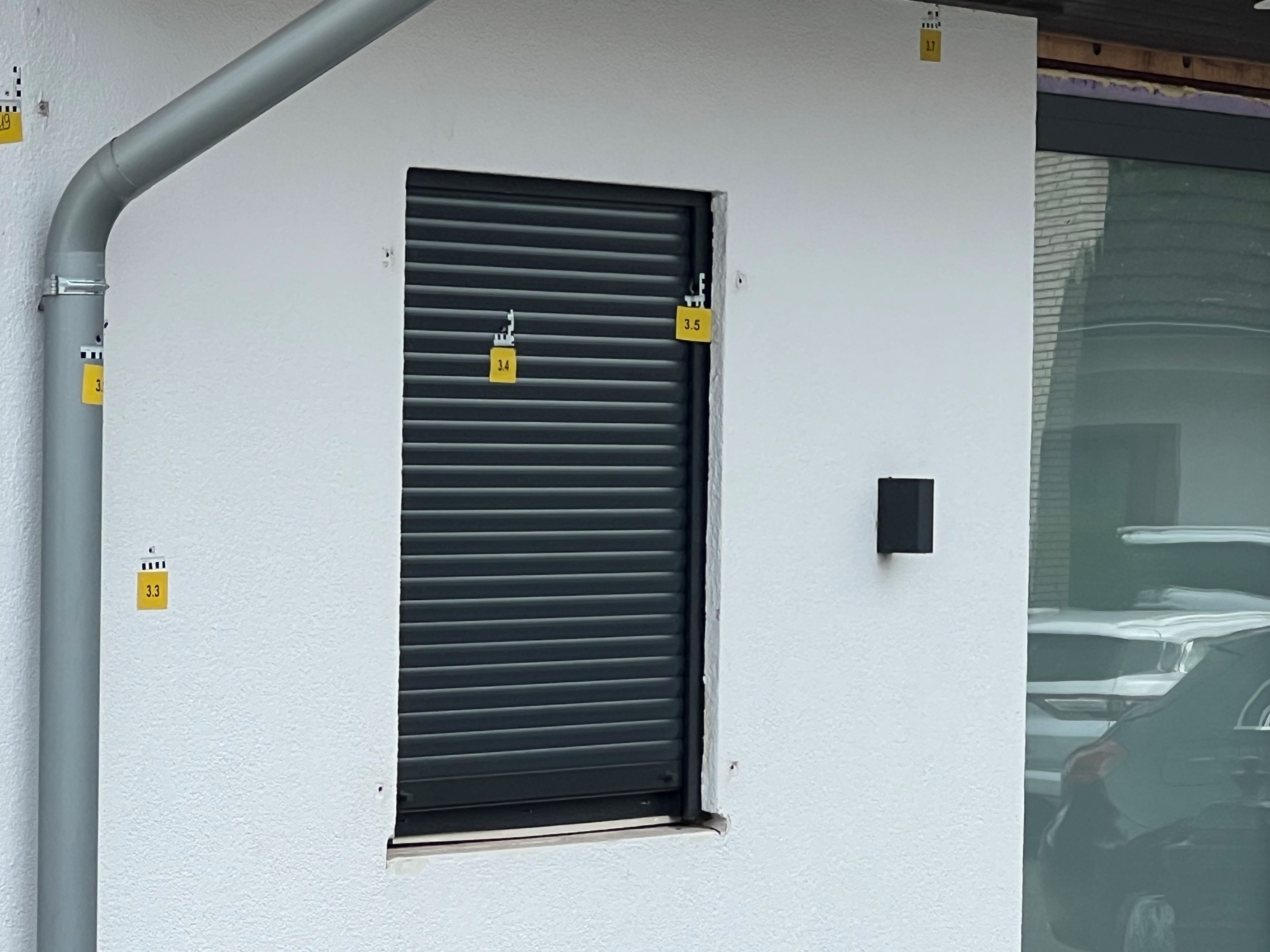 Das Foto zeigt eine Fassade mit durchnummerierten Markierungen an den Einschusslöchern.