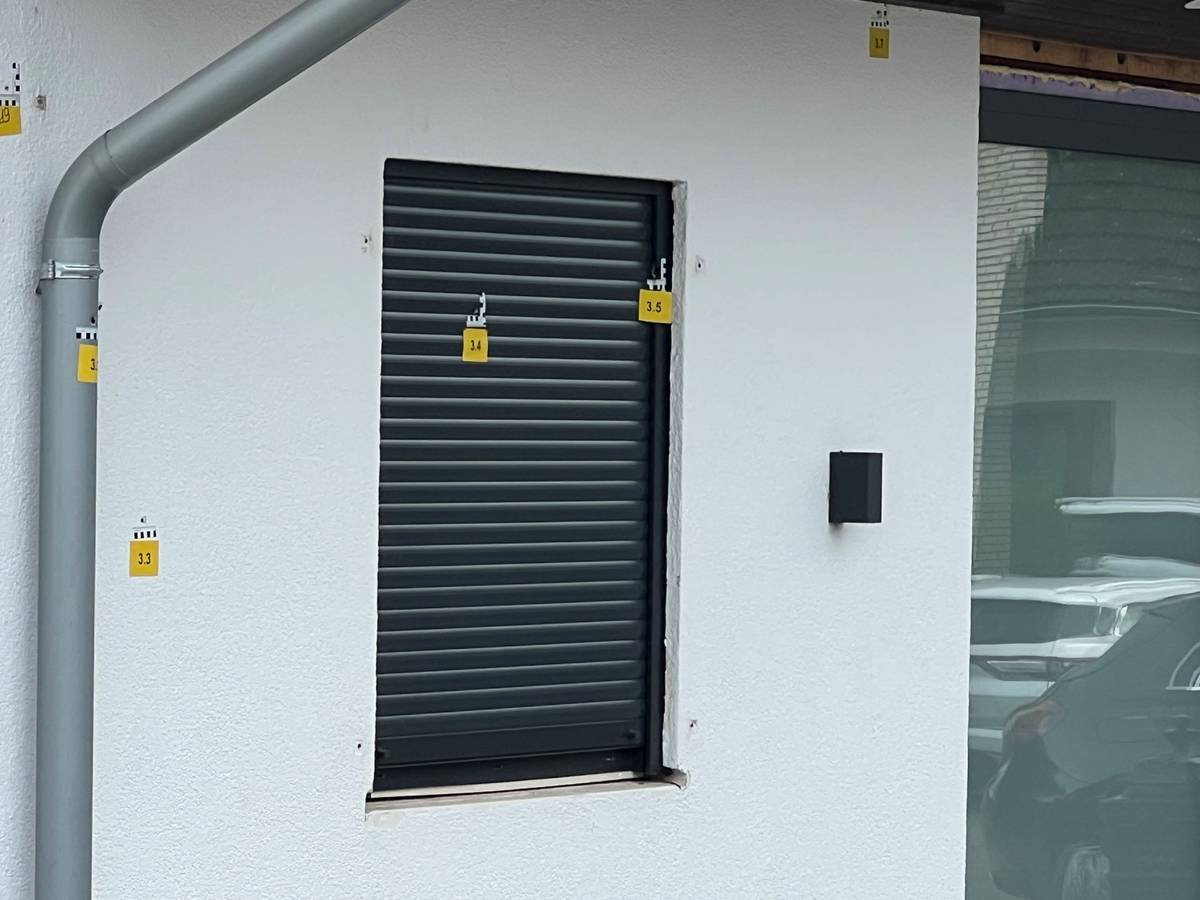 Das Foto zeigt eine Fassade mit durchnummerierten Markierungen an den Einschusslöchern.