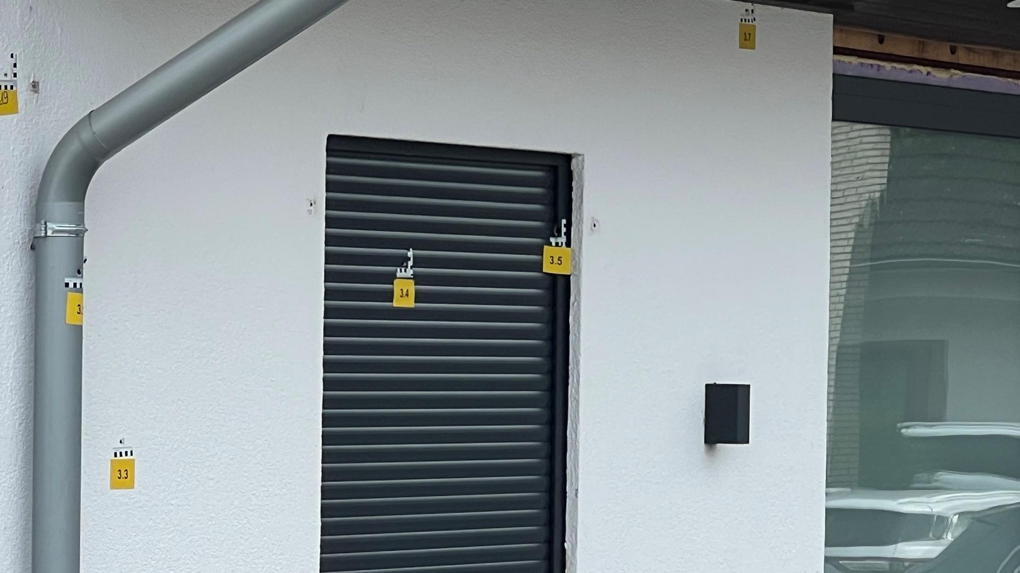 Die Polizei markierte mehrere Einschusslöcher an der Hausfassade.