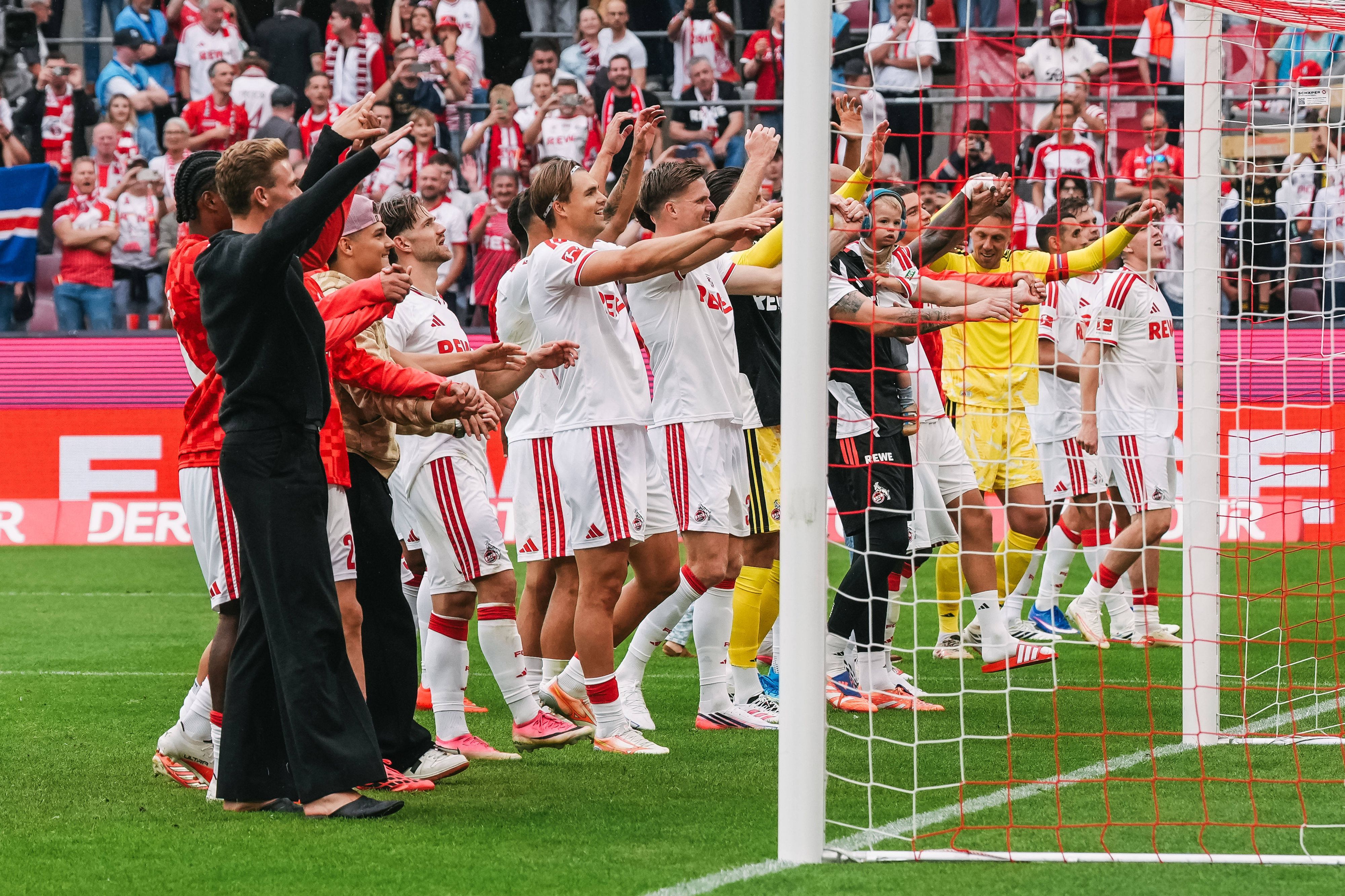 Die Profis des 1. FC Köln tanzen vor der Fankurve.