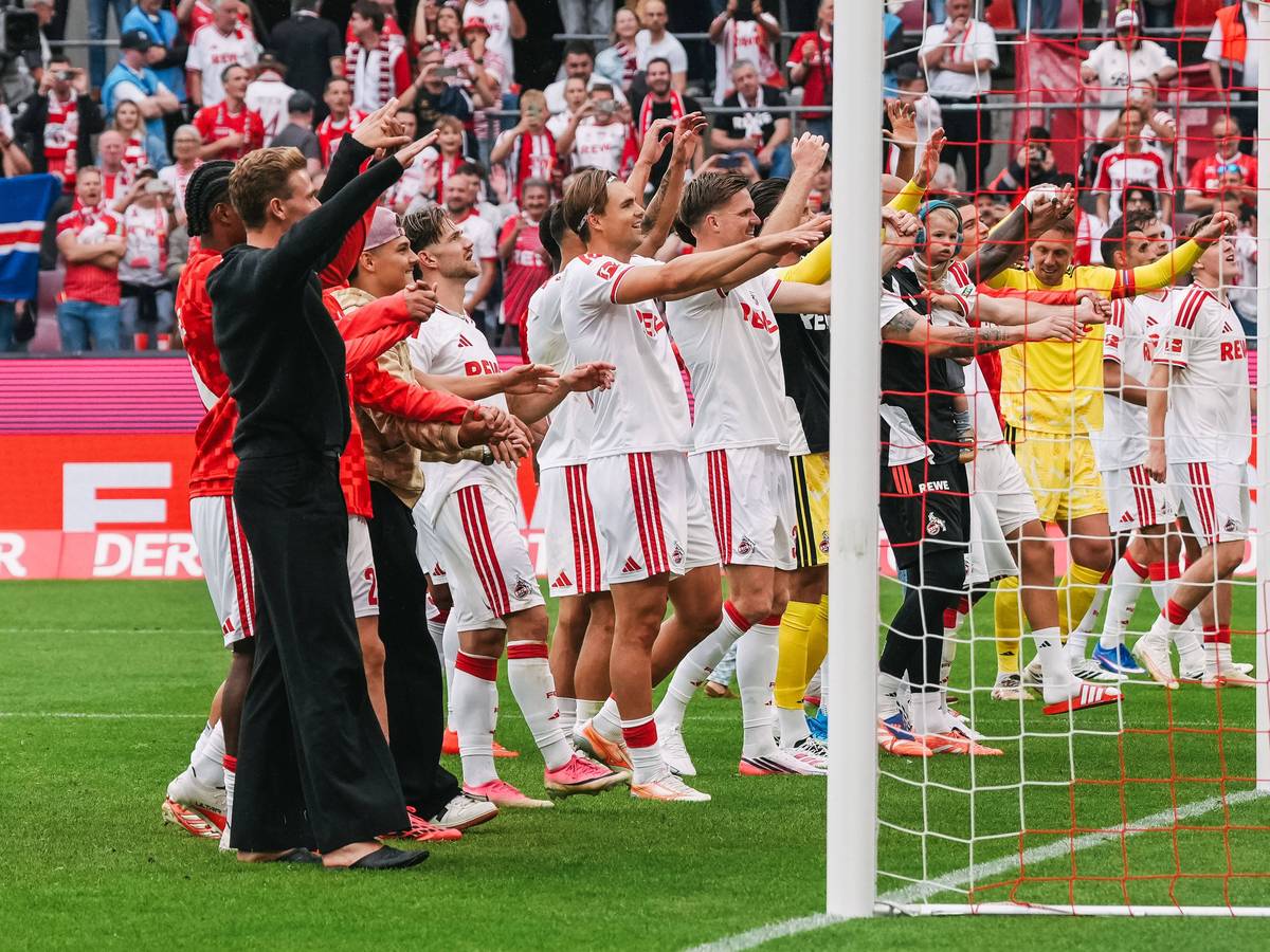 Die Profis des 1. FC Köln tanzen vor der Fankurve.