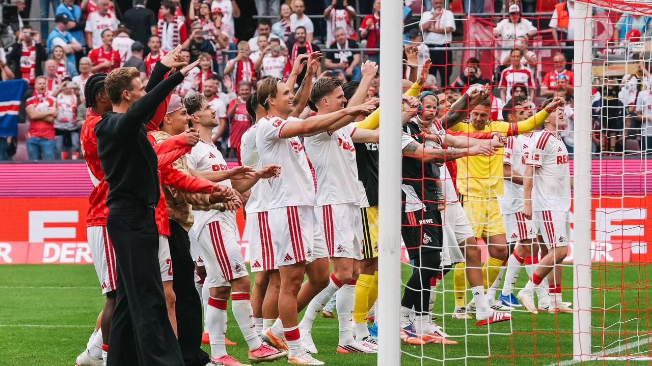 Die Profis des 1. FC Köln tanzen vor der Fankurve.