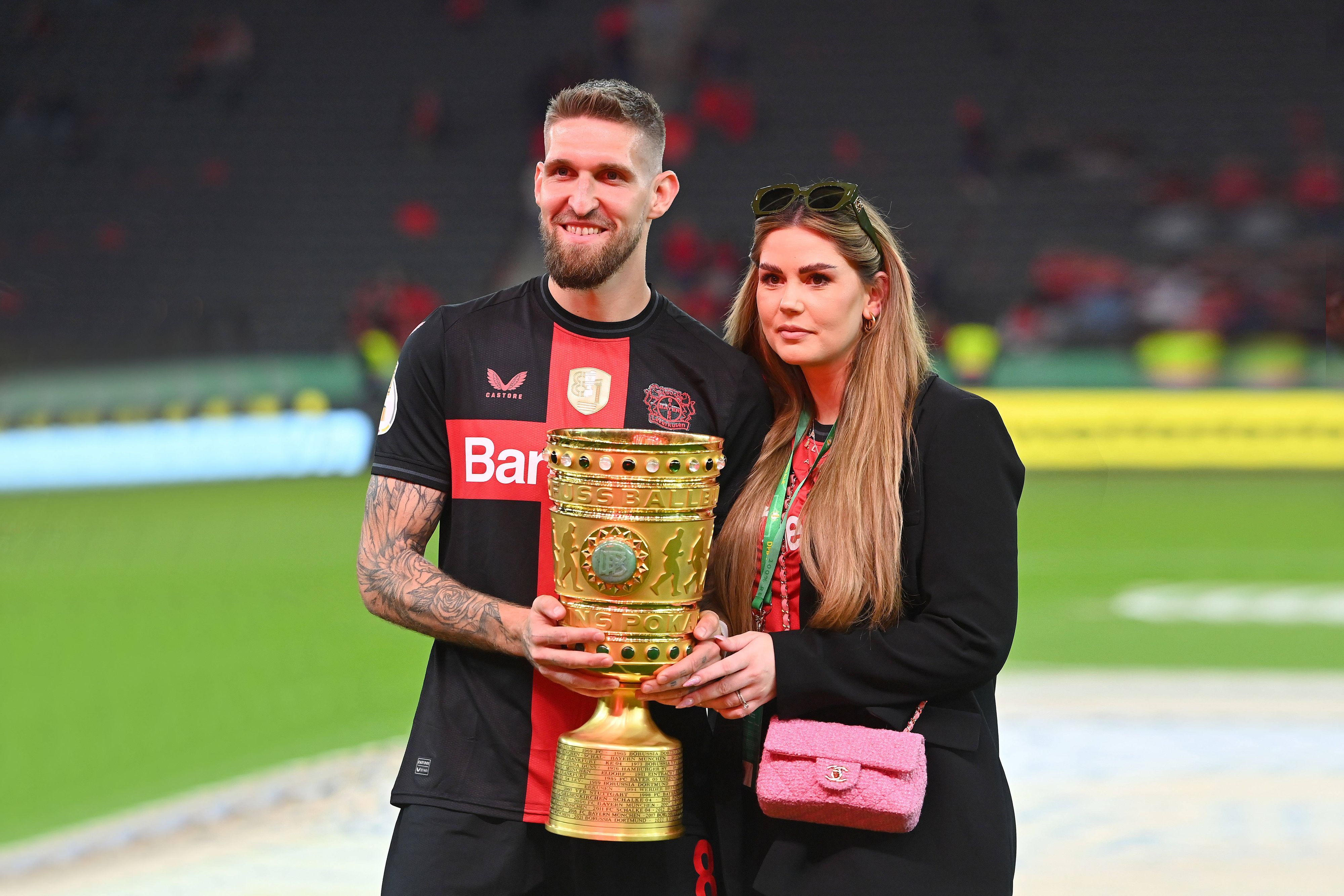 Robert Andrich und Ehefrau Alicia posieren mit dem DFB-Pokal.