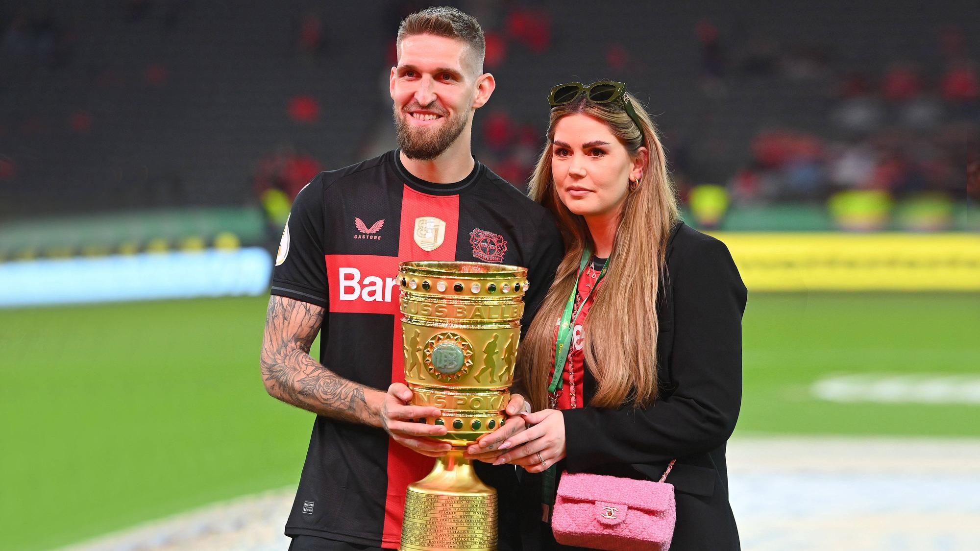 Robert Andrich und Ehefrau Alicia posieren mit dem DFB-Pokal.