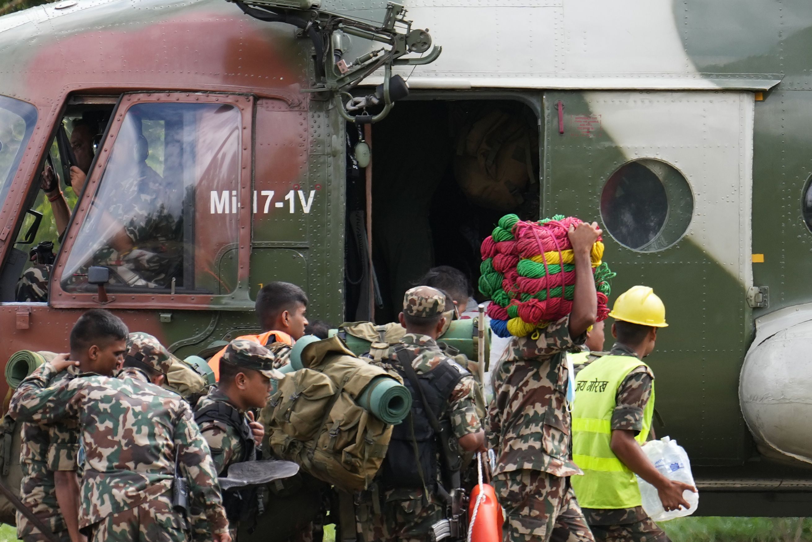 30.08.2026, Nepal, Nuwakot: Rettungskräfte steigen auf einem Hubschrauberlandeplatz im Armeelager in Trishuli im Distrikt Nuwakot in einen bereitstehenden Hubschrauber ein. Foto: Rajesh Kumar Singh/AP/dpa +++ dpa-Bildfunk +++
