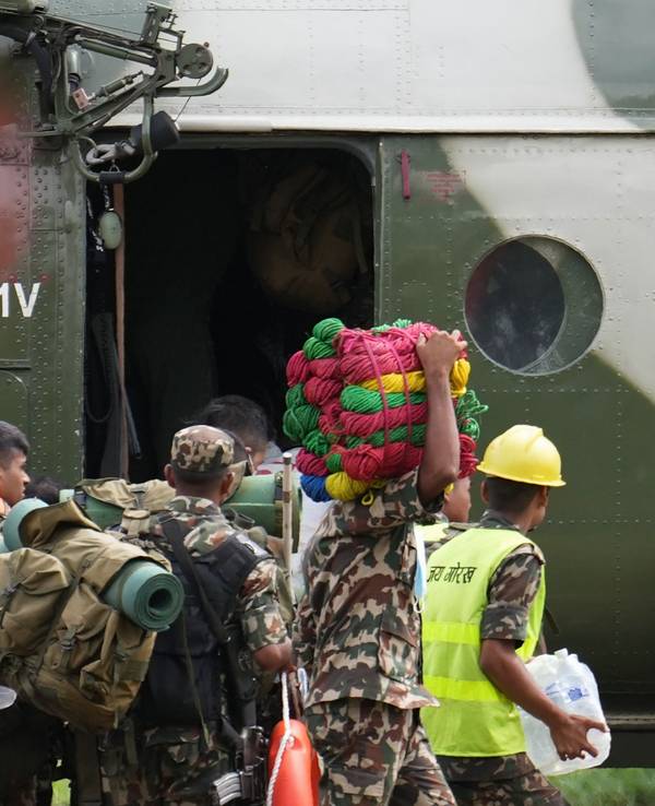 30.08.2026, Nepal, Nuwakot: Rettungskräfte steigen auf einem Hubschrauberlandeplatz im Armeelager in Trishuli im Distrikt Nuwakot in einen bereitstehenden Hubschrauber ein. Foto: Rajesh Kumar Singh/AP/dpa +++ dpa-Bildfunk +++