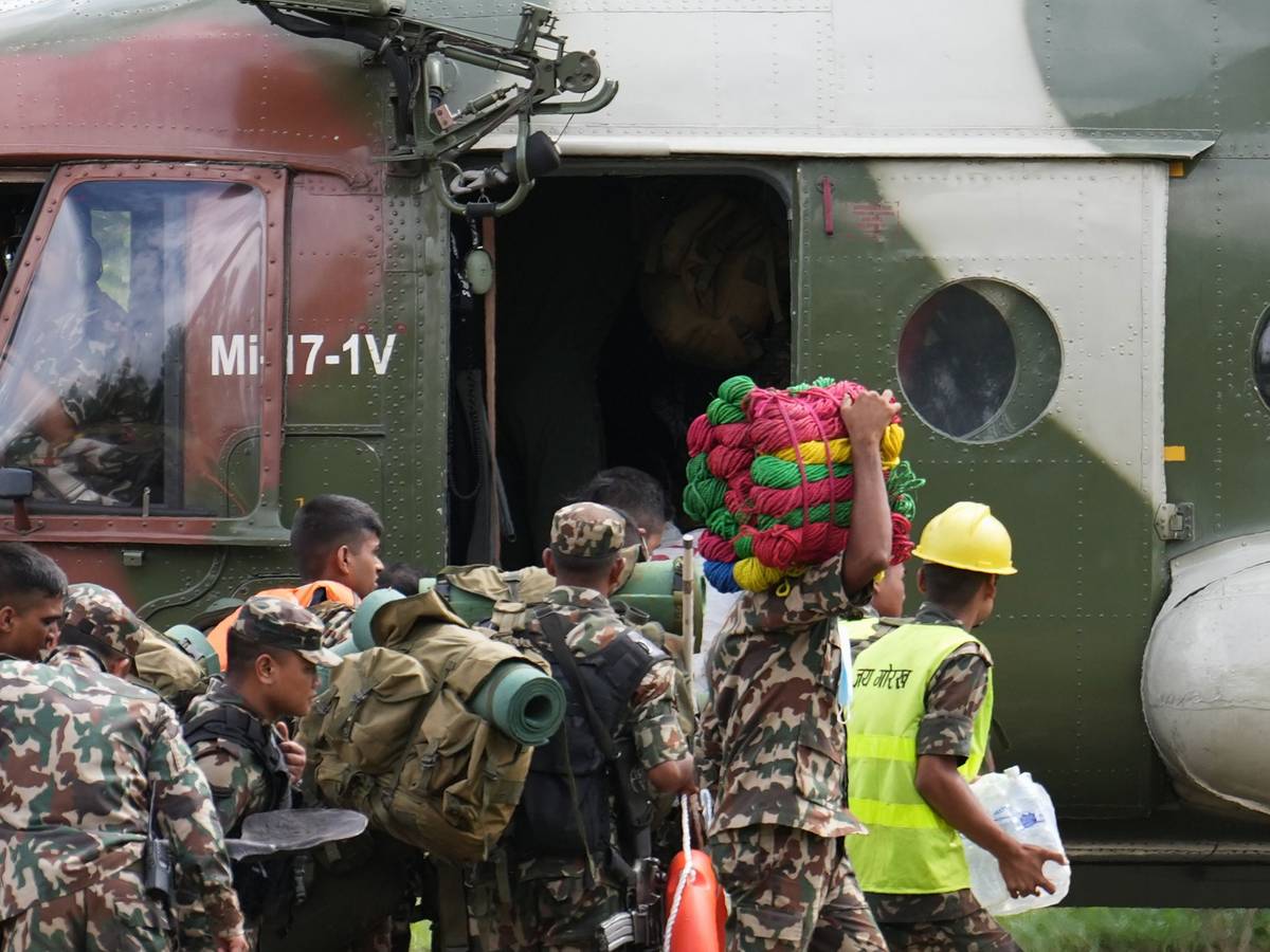 30.08.2026, Nepal, Nuwakot: Rettungskräfte steigen auf einem Hubschrauberlandeplatz im Armeelager in Trishuli im Distrikt Nuwakot in einen bereitstehenden Hubschrauber ein. Foto: Rajesh Kumar Singh/AP/dpa +++ dpa-Bildfunk +++