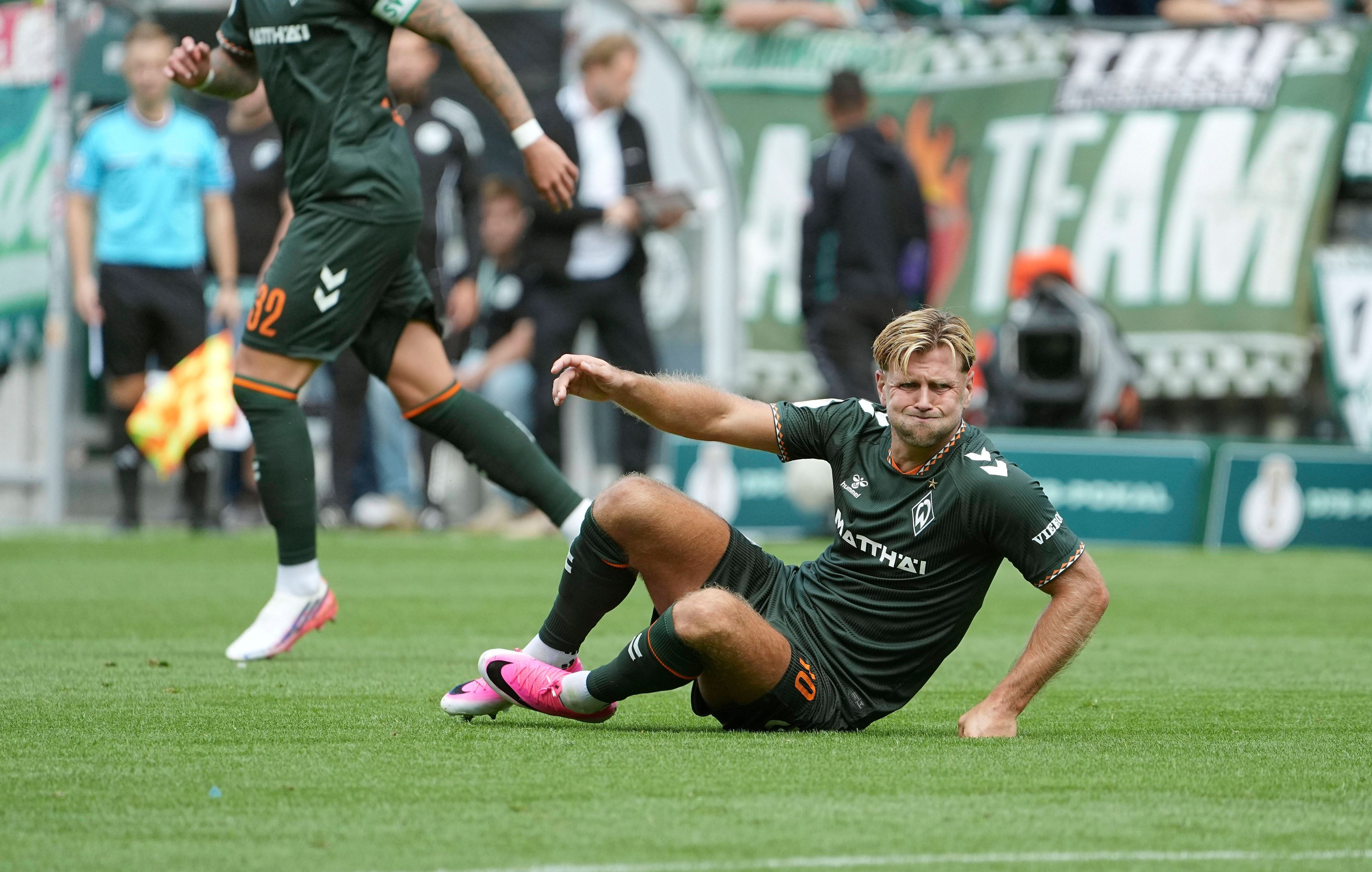 Niclas Füllkrug sitzt auf dem Boden.