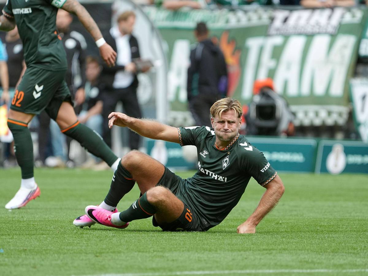 Niclas Füllkrug sitzt auf dem Boden.
