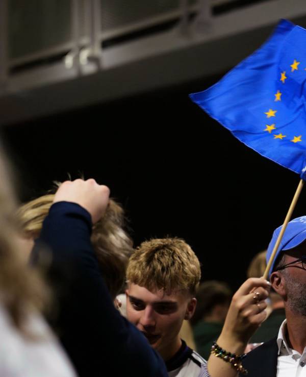 30.08.2026, Island, Reykjavík: Ein Mann schwenkt eine Fahne der Europäischen Union, während einer Wahlnachtveranstaltung der «Ja»-Kampagne. Foto: Marco Di Marco/AP/dpa +++ dpa-Bildfunk +++