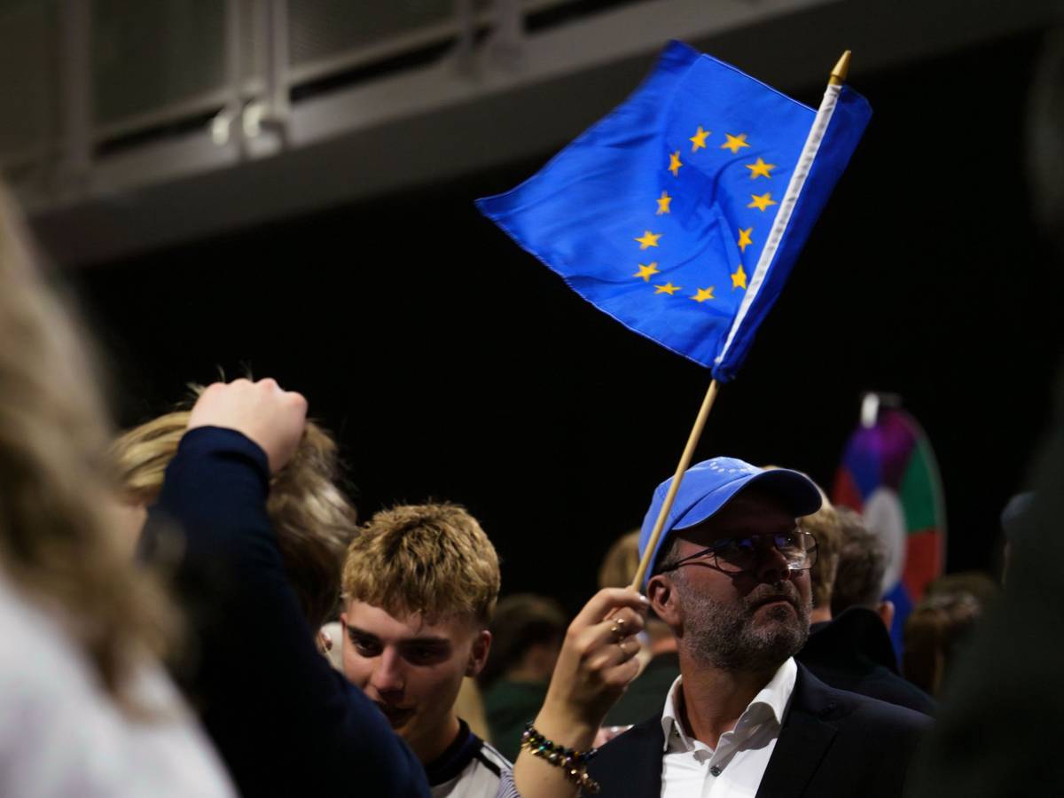 30.08.2026, Island, Reykjavík: Ein Mann schwenkt eine Fahne der Europäischen Union, während einer Wahlnachtveranstaltung der «Ja»-Kampagne. Foto: Marco Di Marco/AP/dpa +++ dpa-Bildfunk +++
