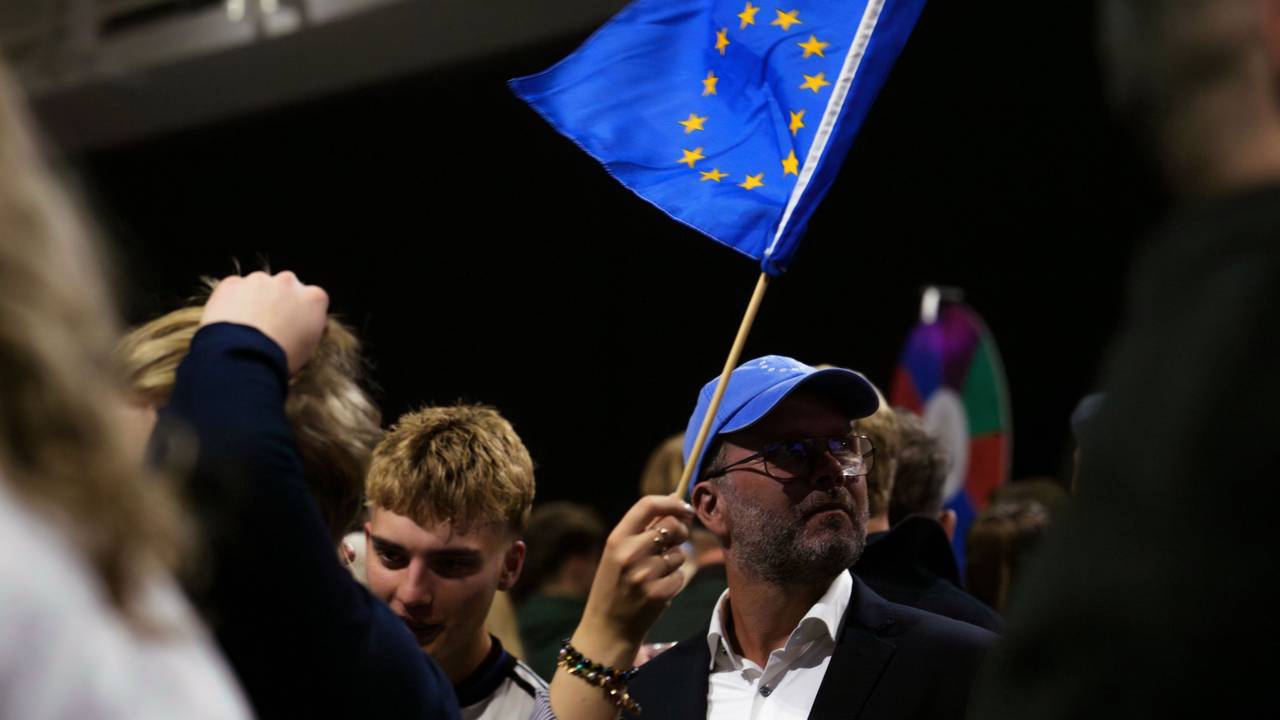 30.08.2026, Island, Reykjavík: Ein Mann schwenkt eine Fahne der Europäischen Union, während einer Wahlnachtveranstaltung der «Ja»-Kampagne. Foto: Marco Di Marco/AP/dpa +++ dpa-Bildfunk +++