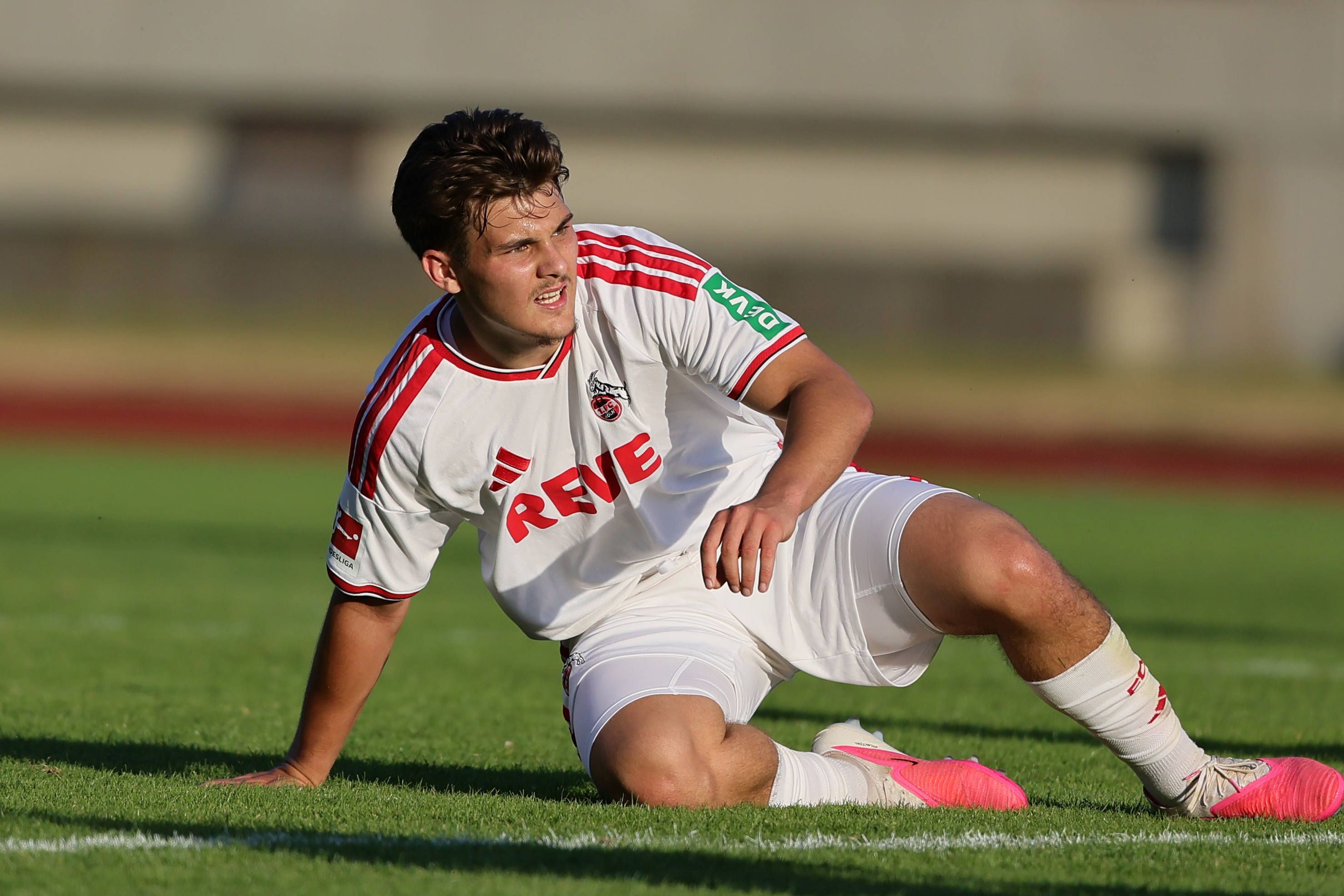 Beim Spiel des 1. FC Köln sitzt Patrik Kristal auf dem Rasen.