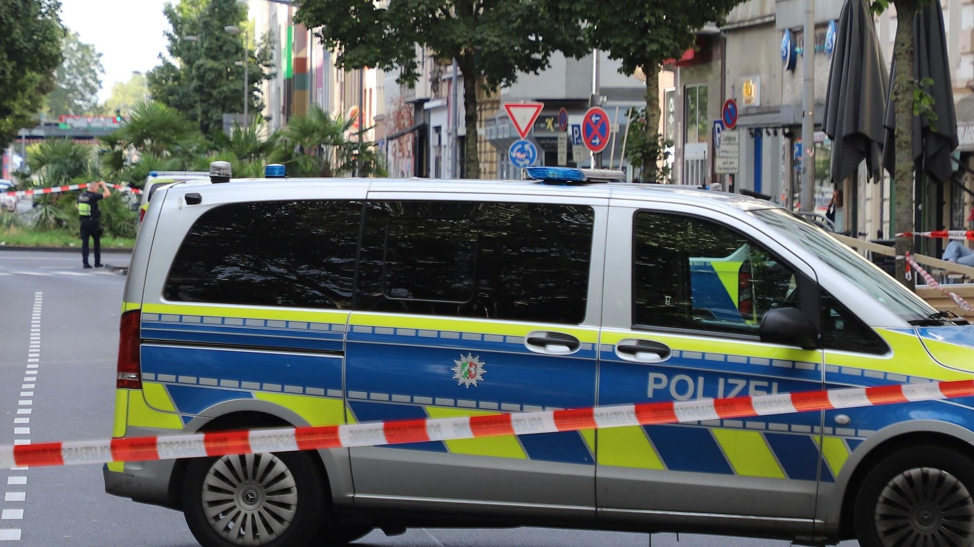 Ein Fahrzeug der Polizei steht hinter einer Absperrung auf einer Straße.