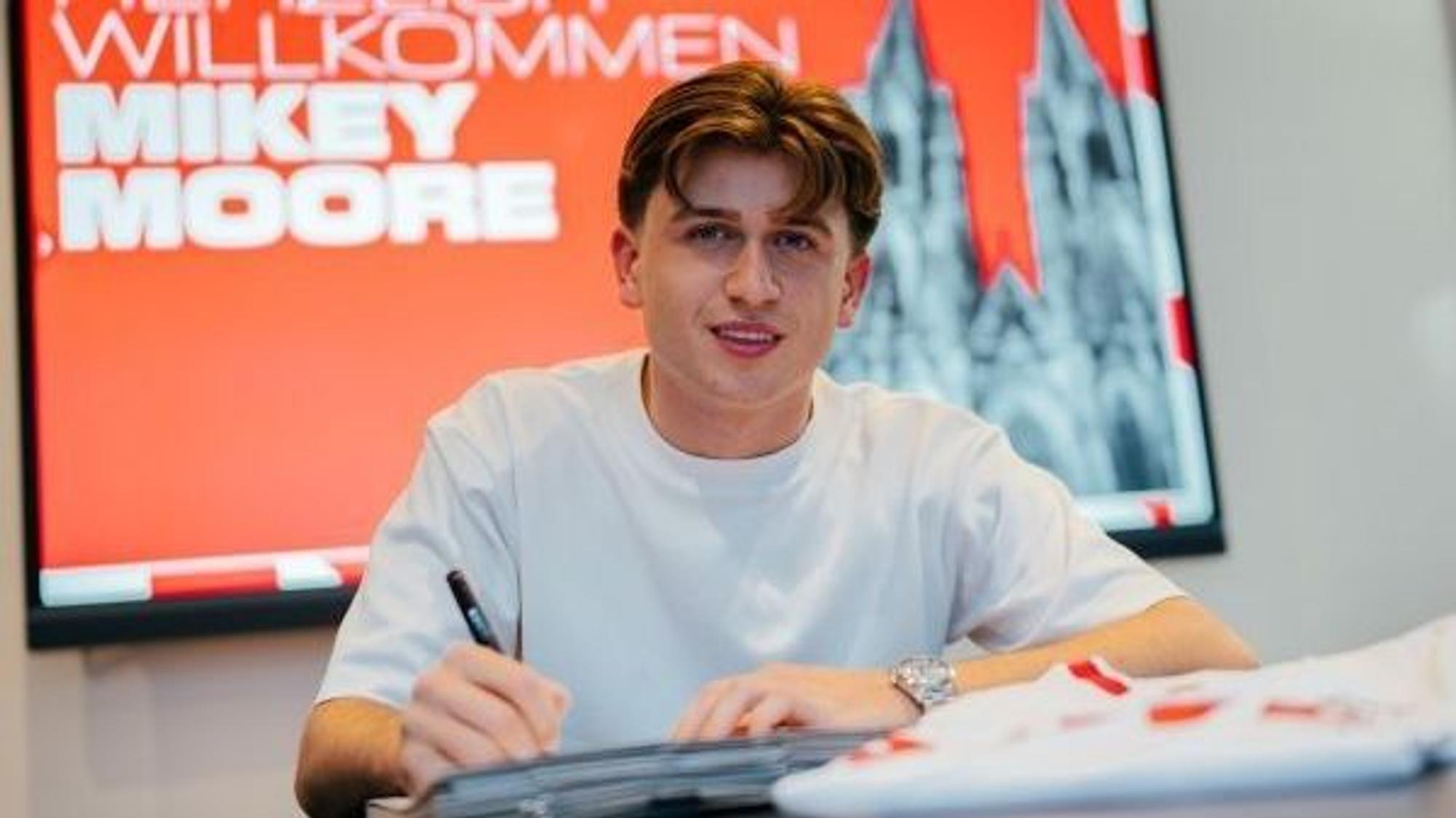 Mikey Moore unterschreibt einen Vertrag.