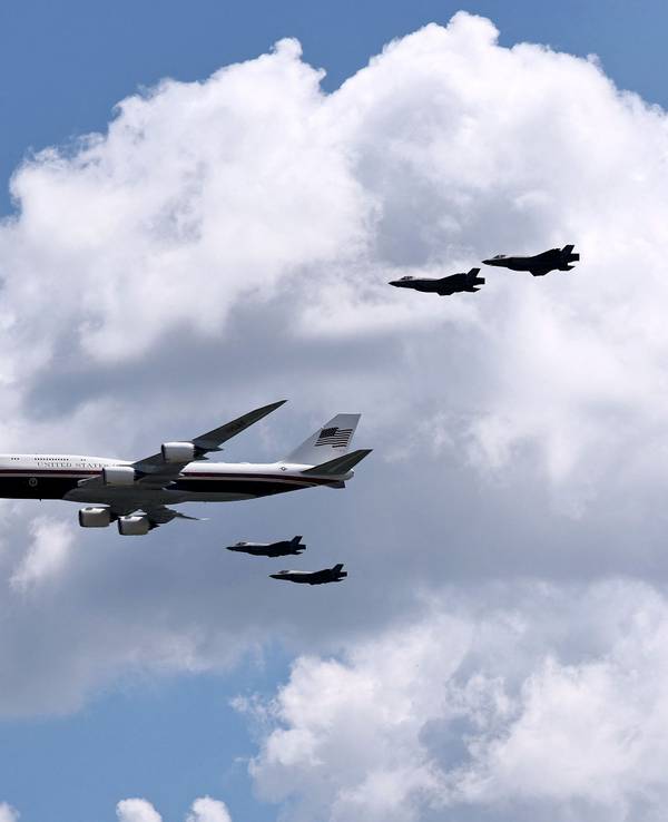 Die Air Force One mit vier Kampfjets bei einem Flyover.