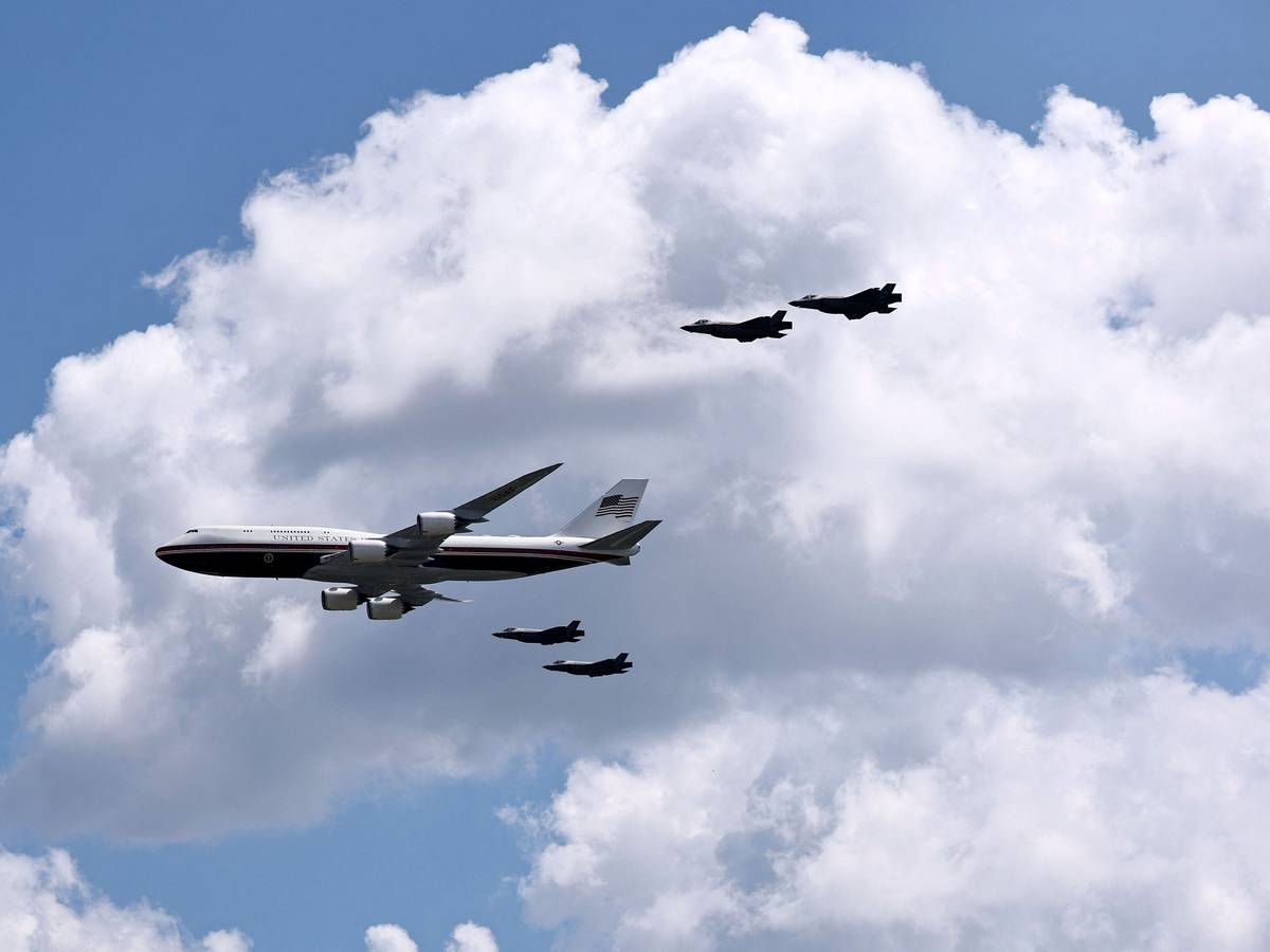 Die Air Force One mit vier Kampfjets bei einem Flyover.